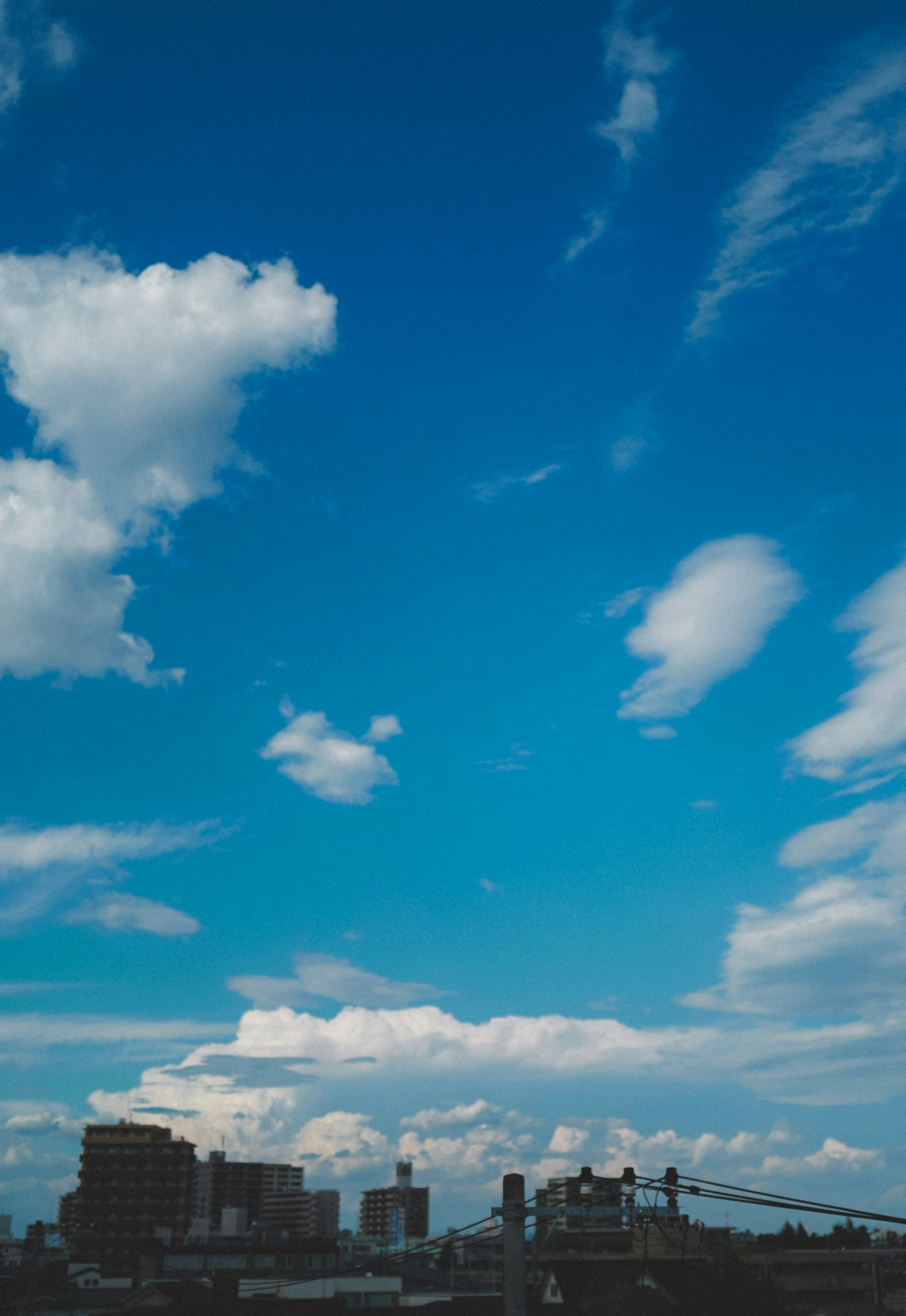 青空と白い雲が広がる都市の風景