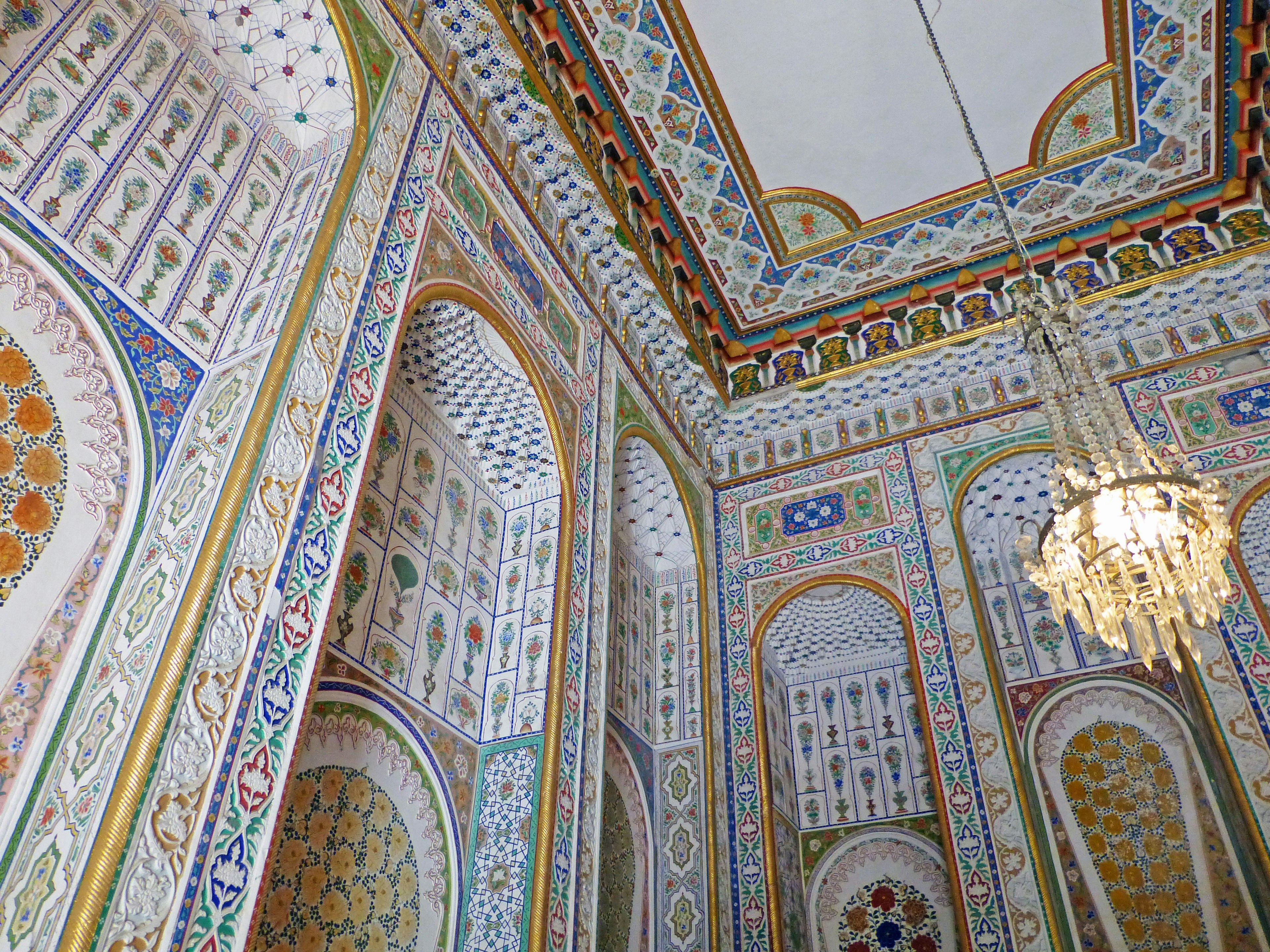 Interior of a room with intricate decorations featuring a chandelier and colorful tiles