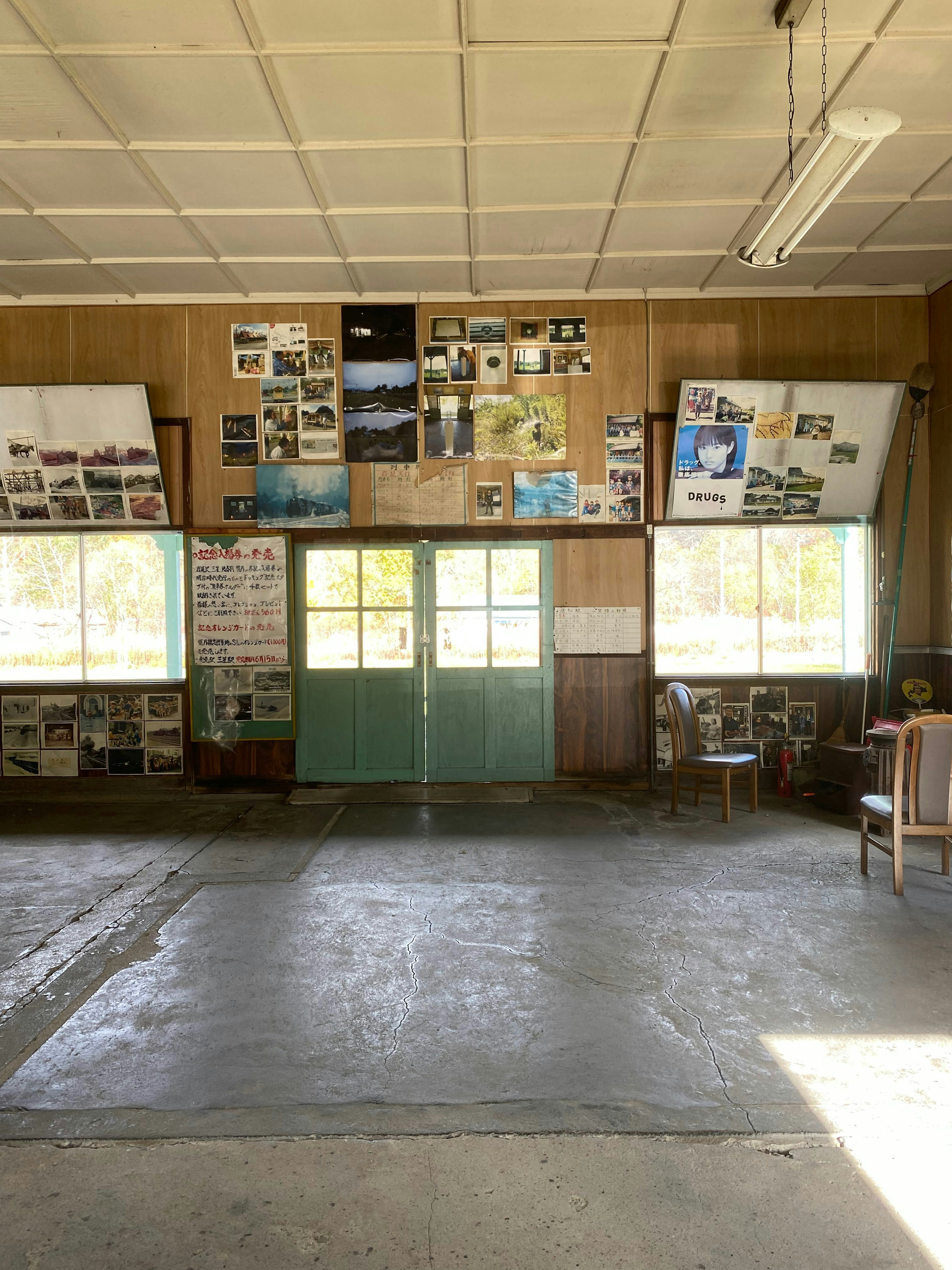 Bright indoor space with photos displayed on the walls Concrete floor with distinctive green doors