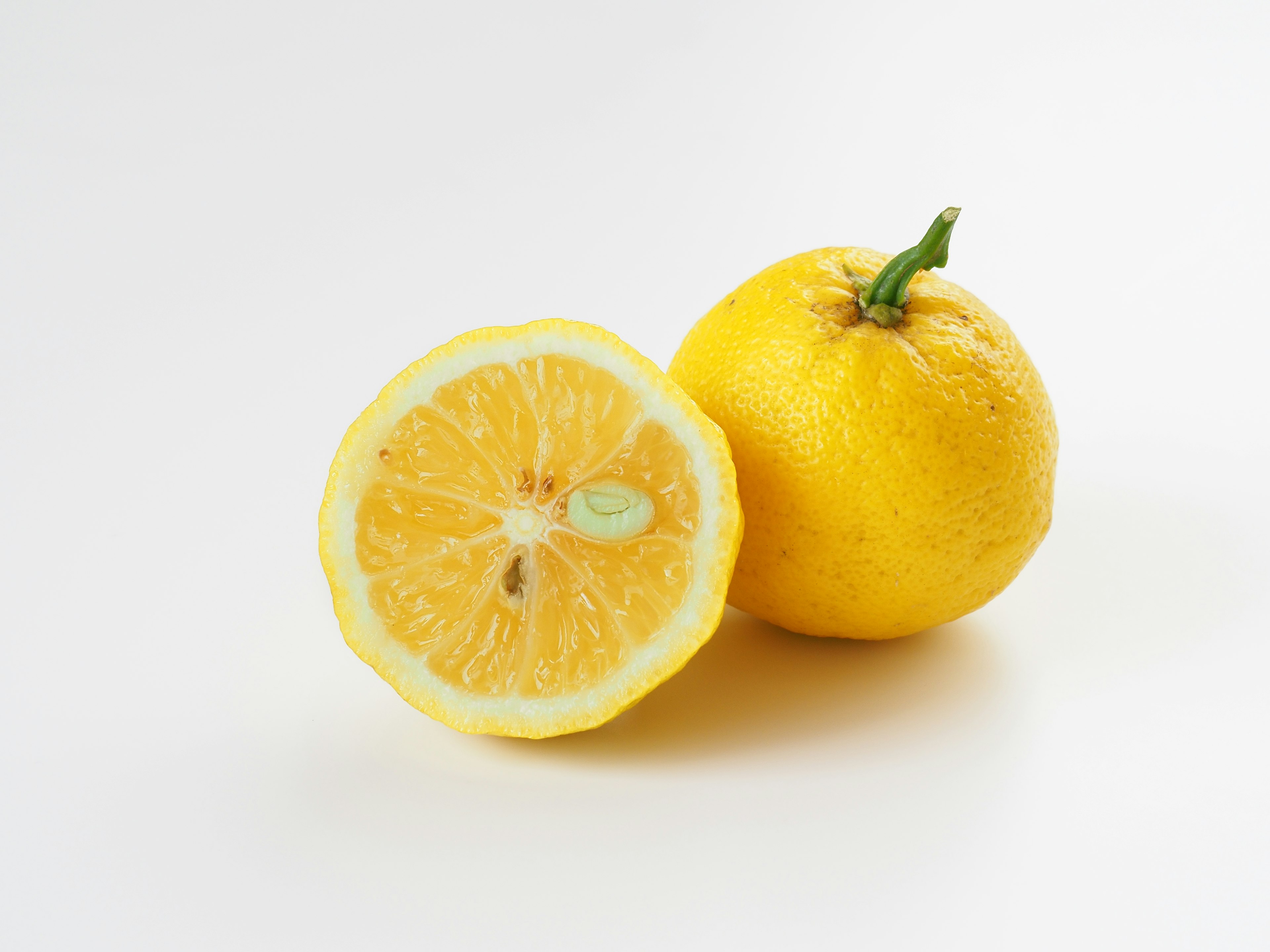 Image of a whole lemon and a halved lemon showing the inside