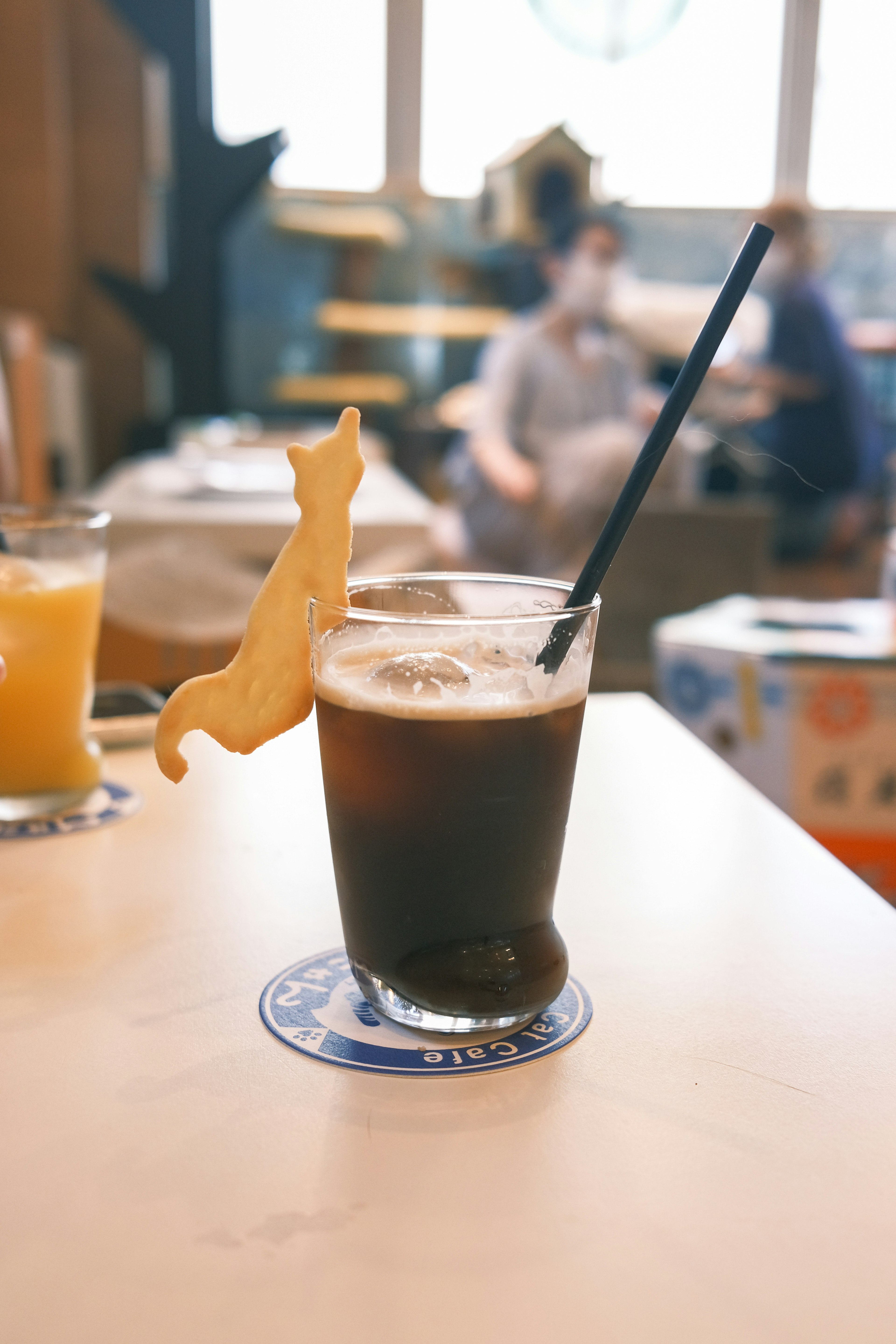 Iced coffee with a cat-shaped cookie garnish