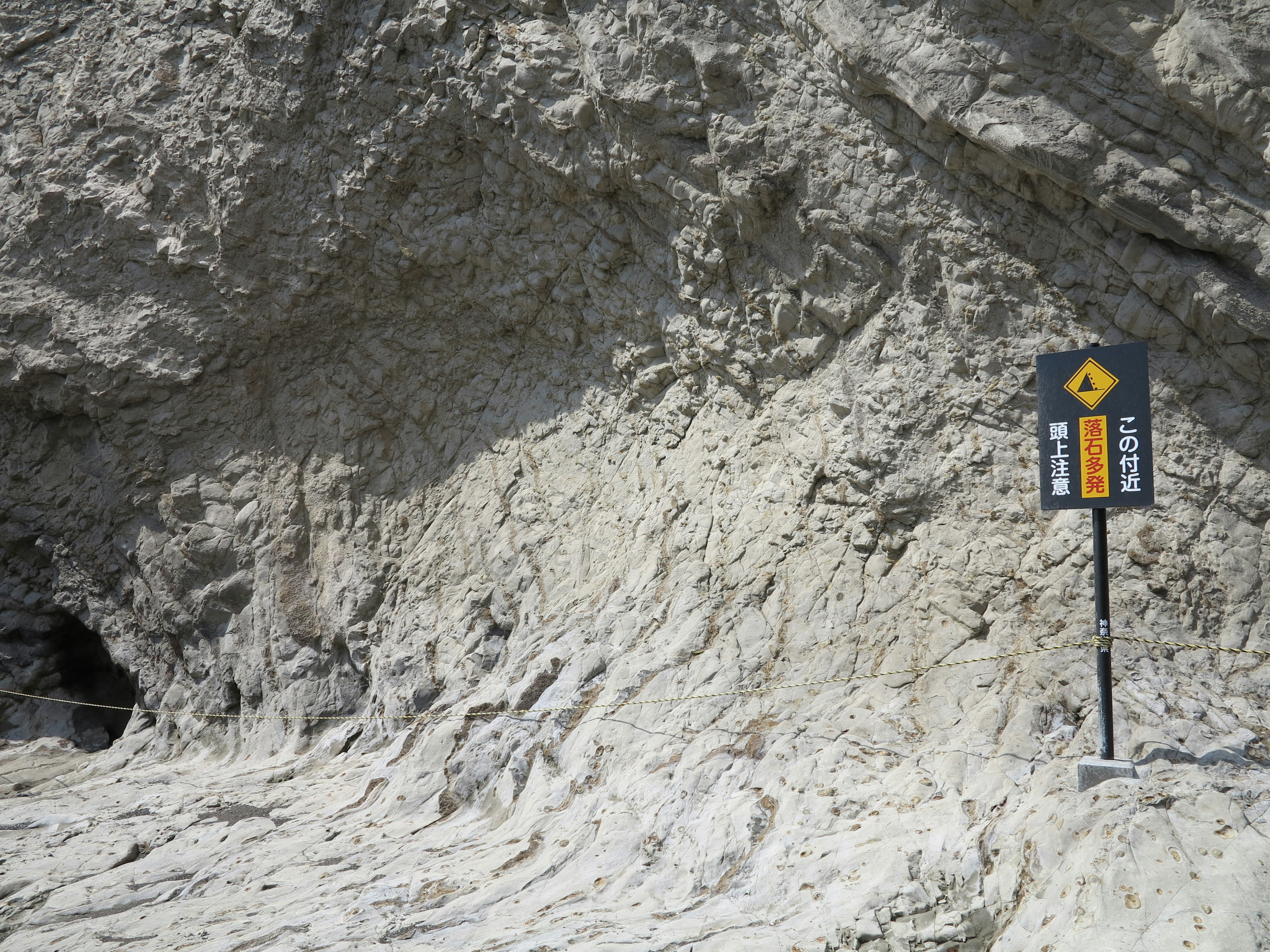 Rocky surface with a warning sign indicating caution