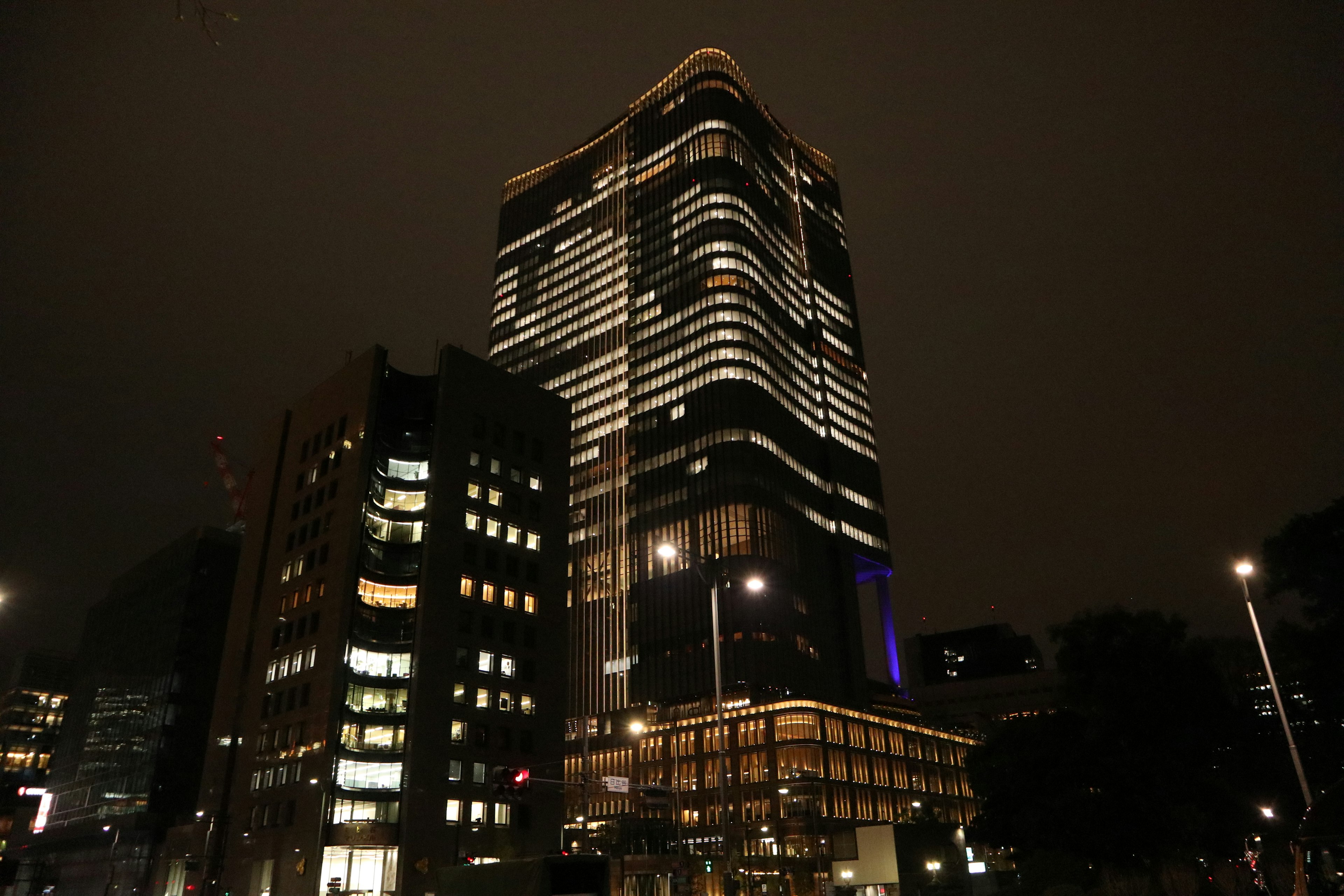 Exterior of a tall building illuminated at night in an urban setting