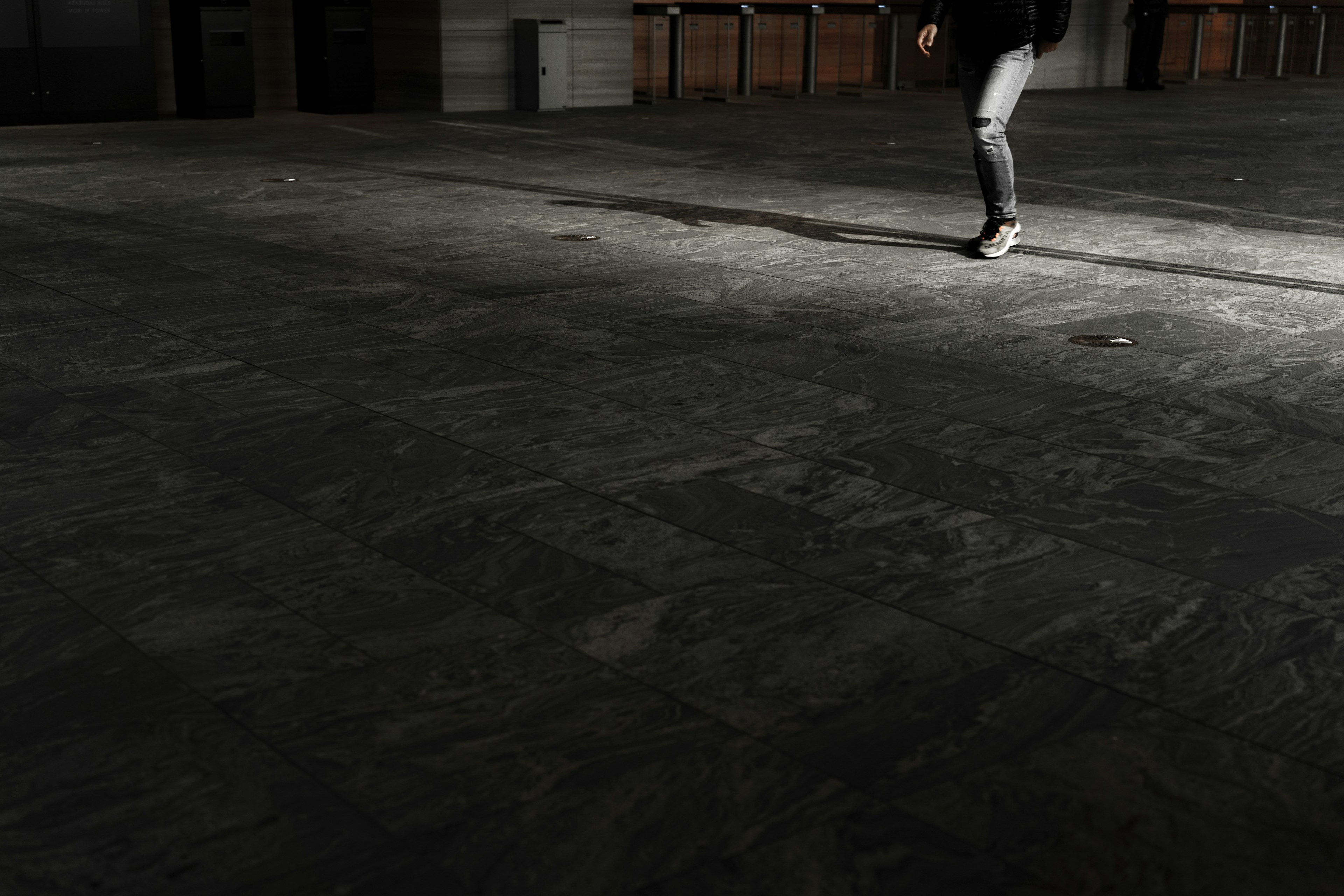 Image capturing a person's feet walking in a dimly lit space