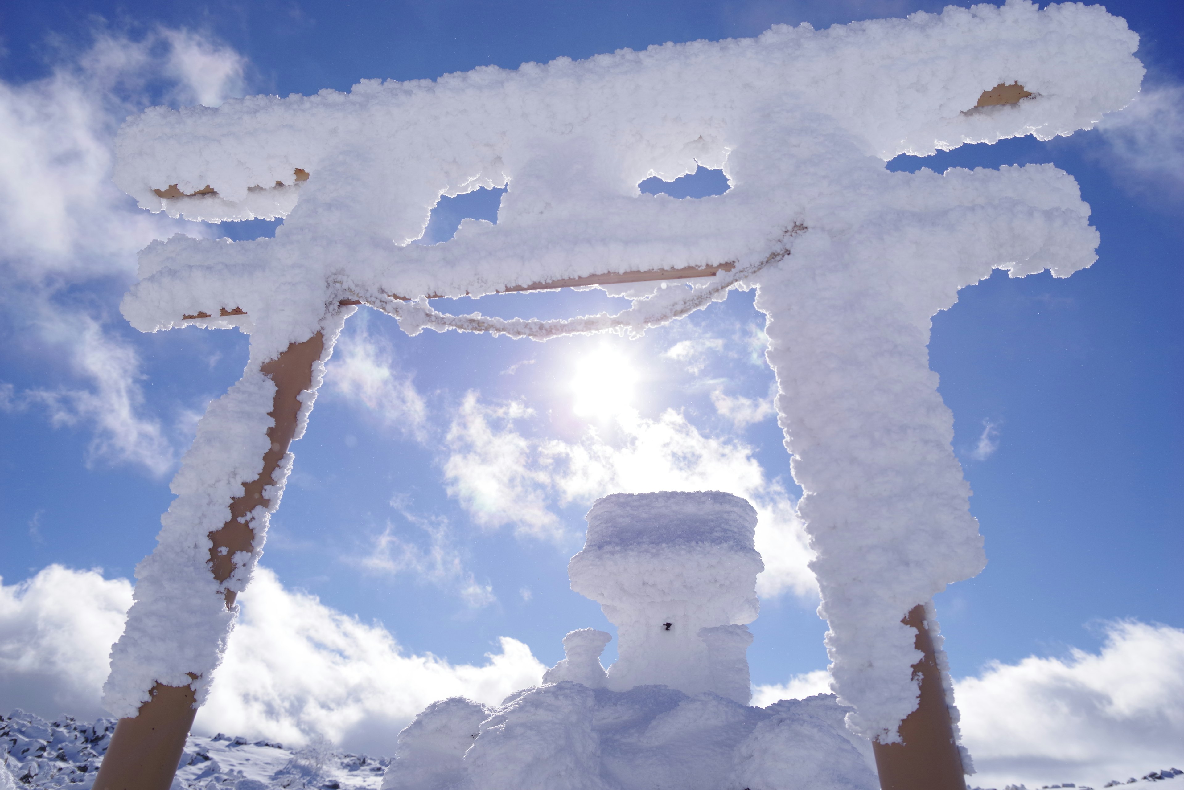 被雪覆蓋的鳥居與明亮的天空