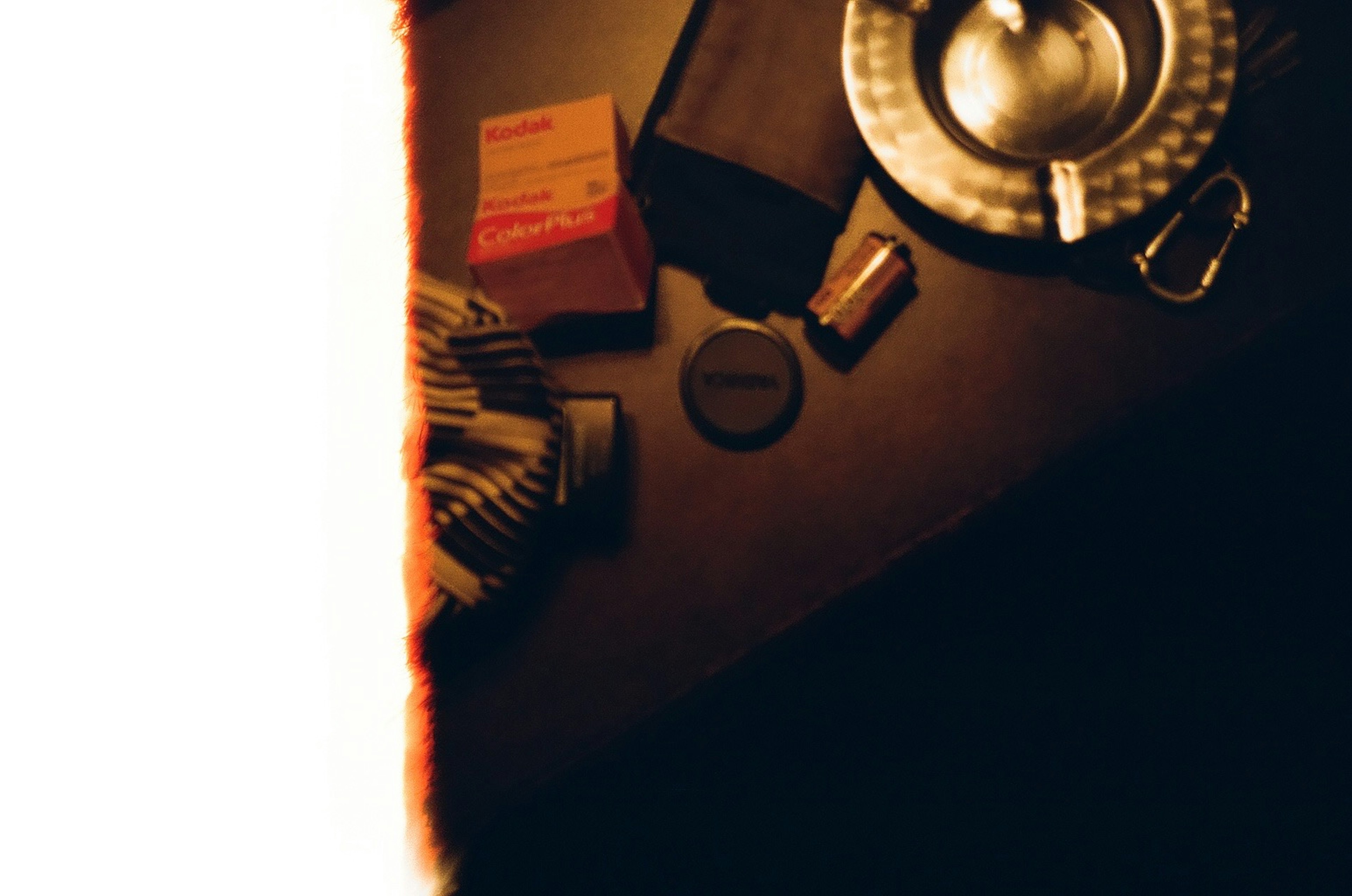 Overhead view of various items on a table silver plate small black circular object red package cards