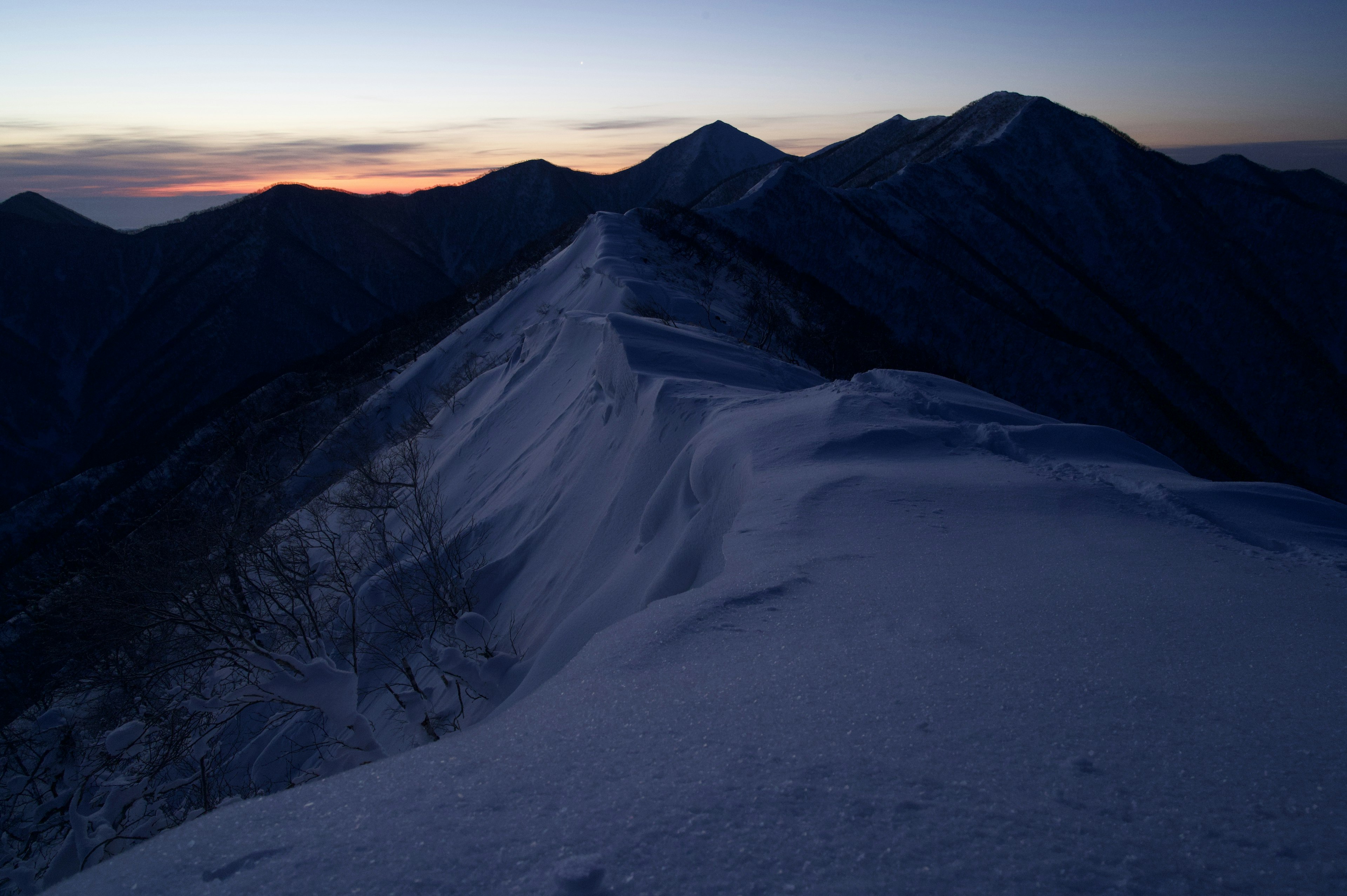 夕焼けの山脈と雪に覆われた尾根の風景