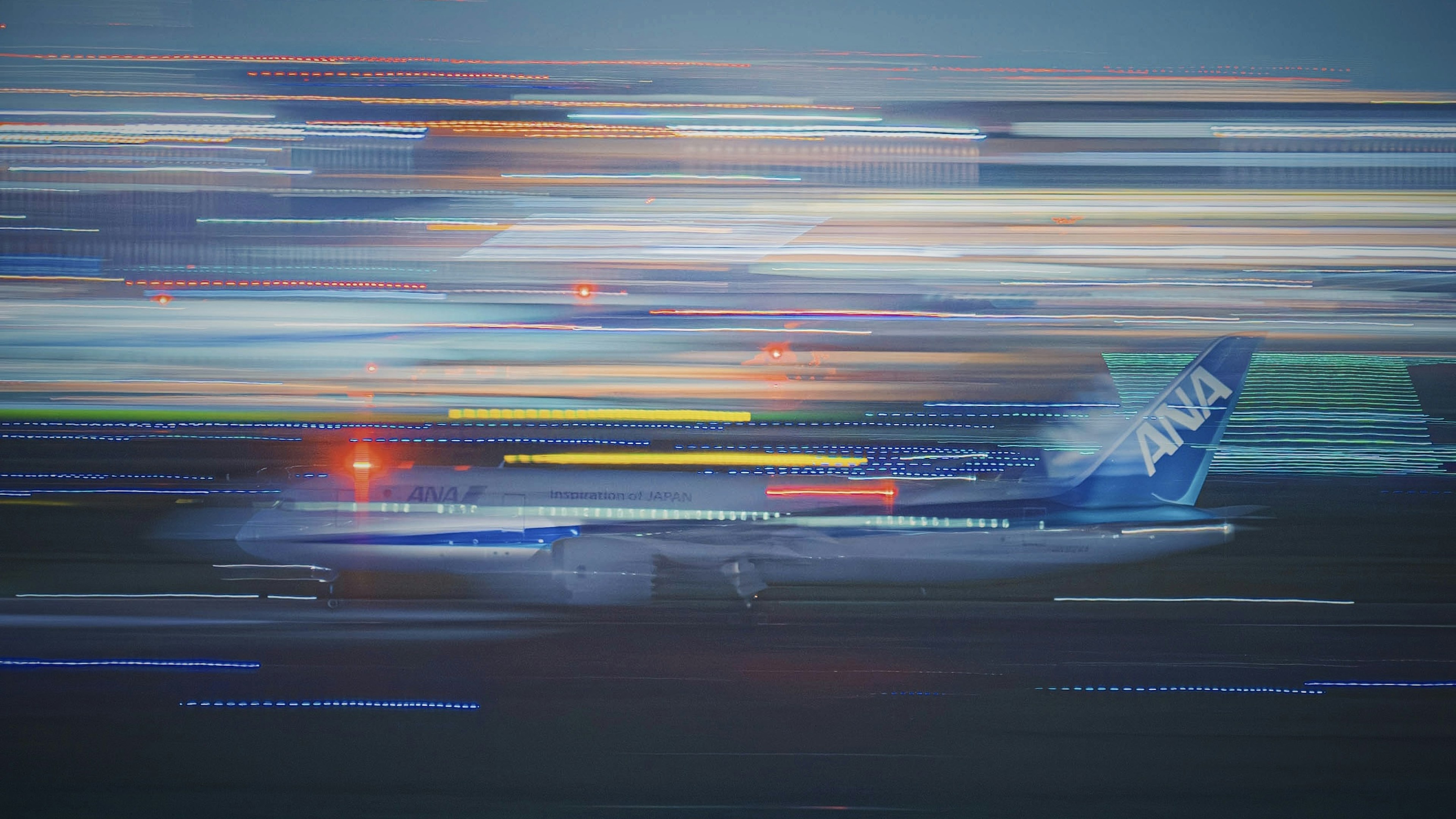 Blue aircraft in motion on runway with streaks of light surrounding it