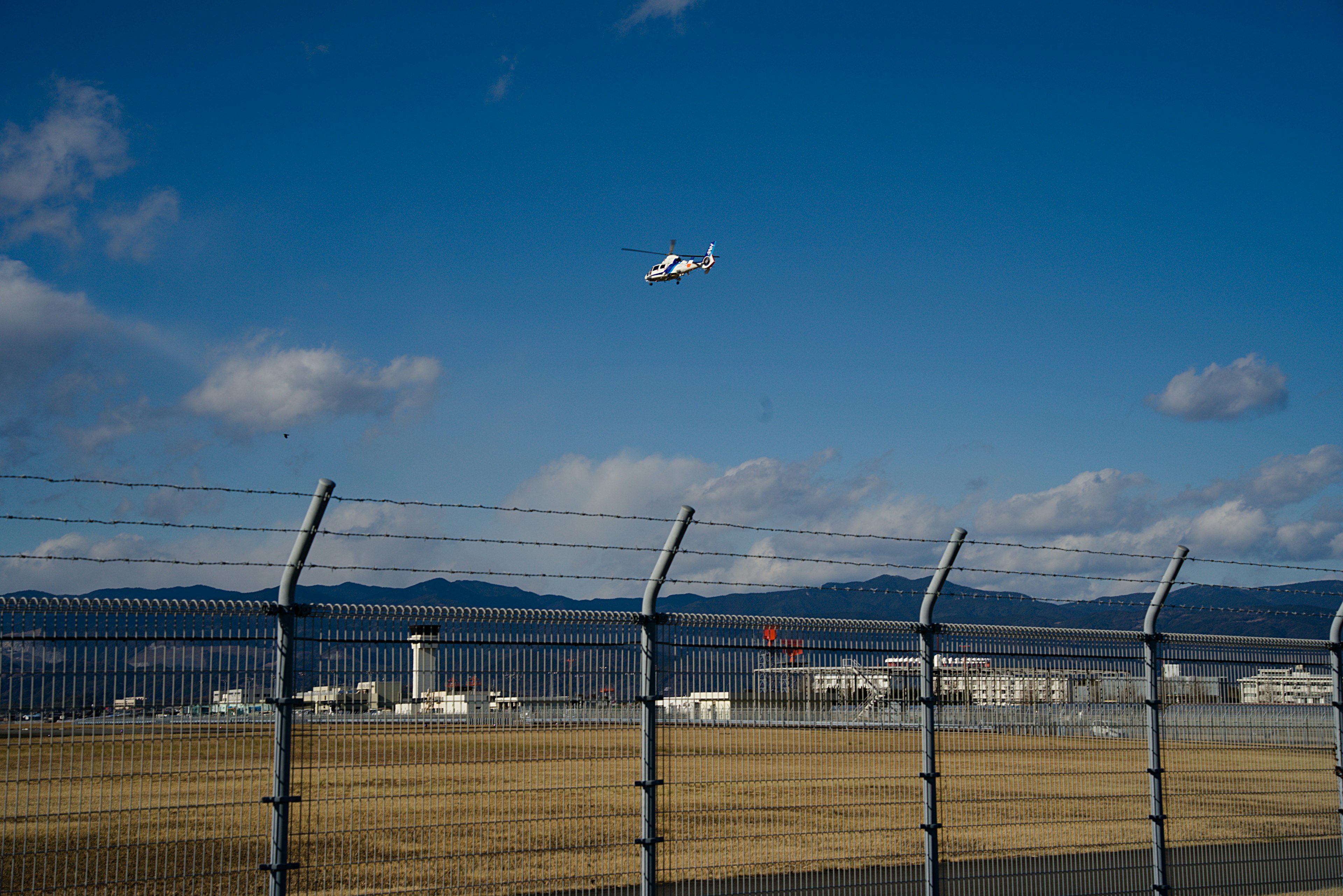 Petit avion survolant une piste sous un ciel bleu