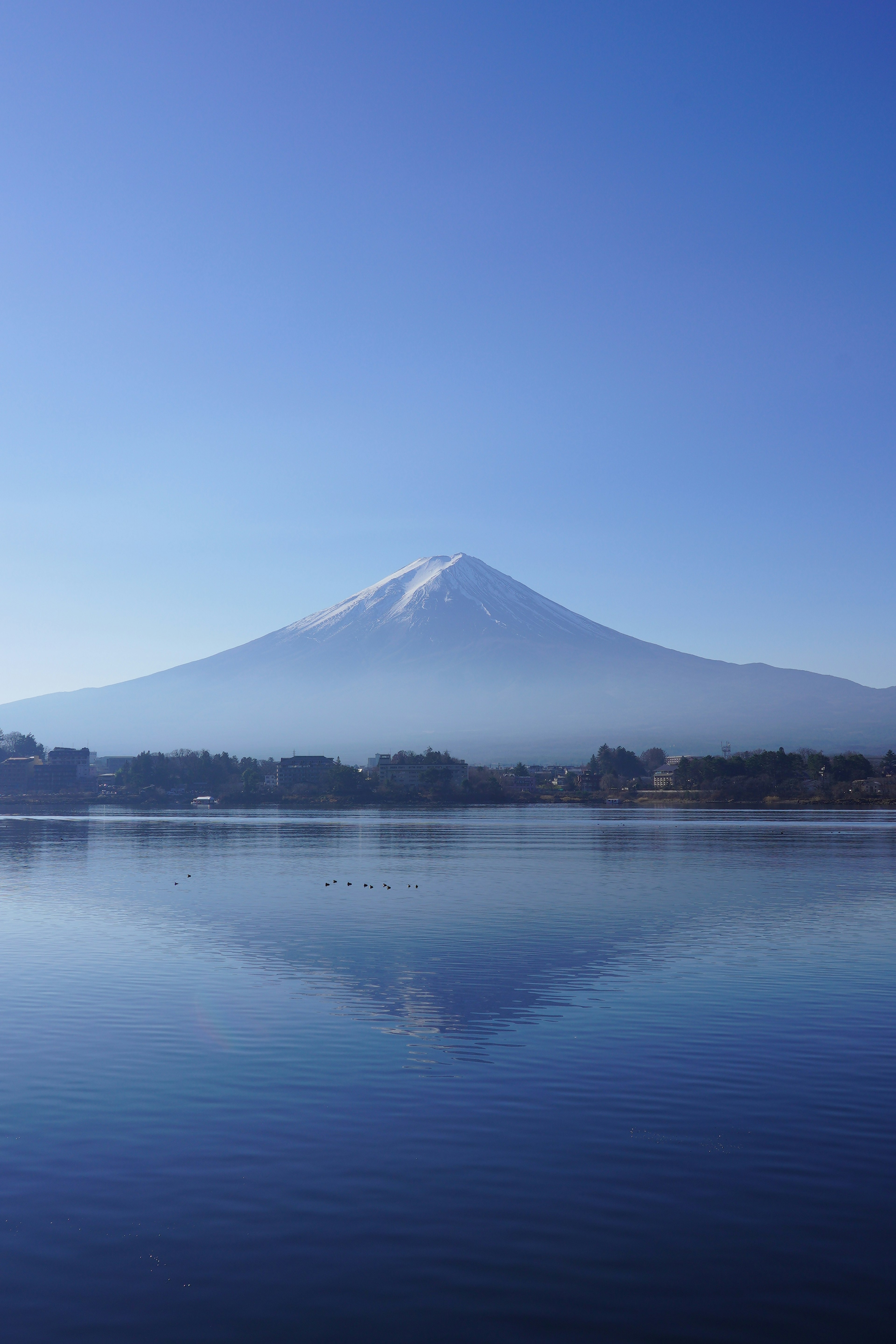 富士山の美しい雪の頂が湖に映る青い空の風景