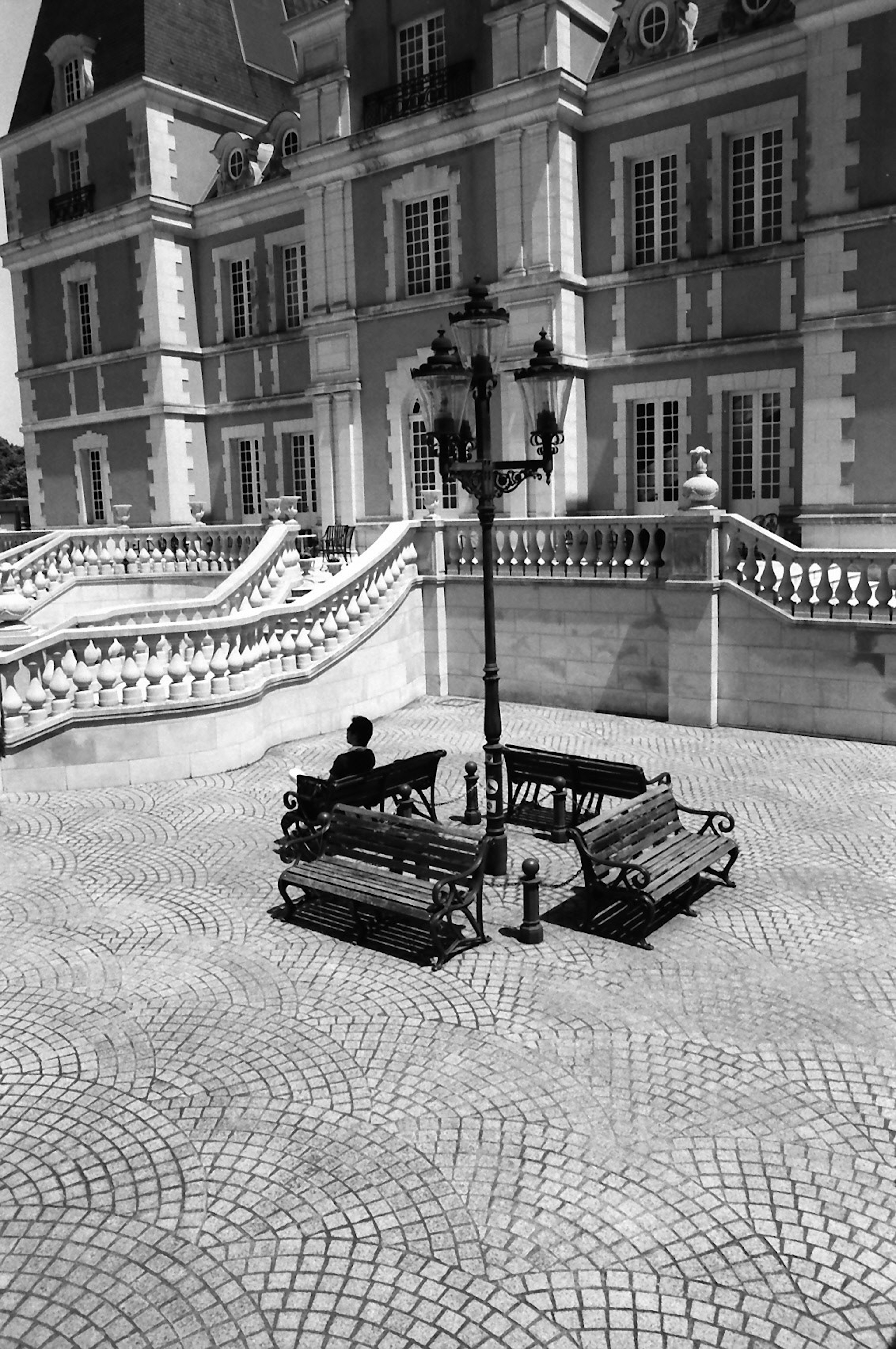 Una piazza con panchine e un lampione di fronte a un bel edificio