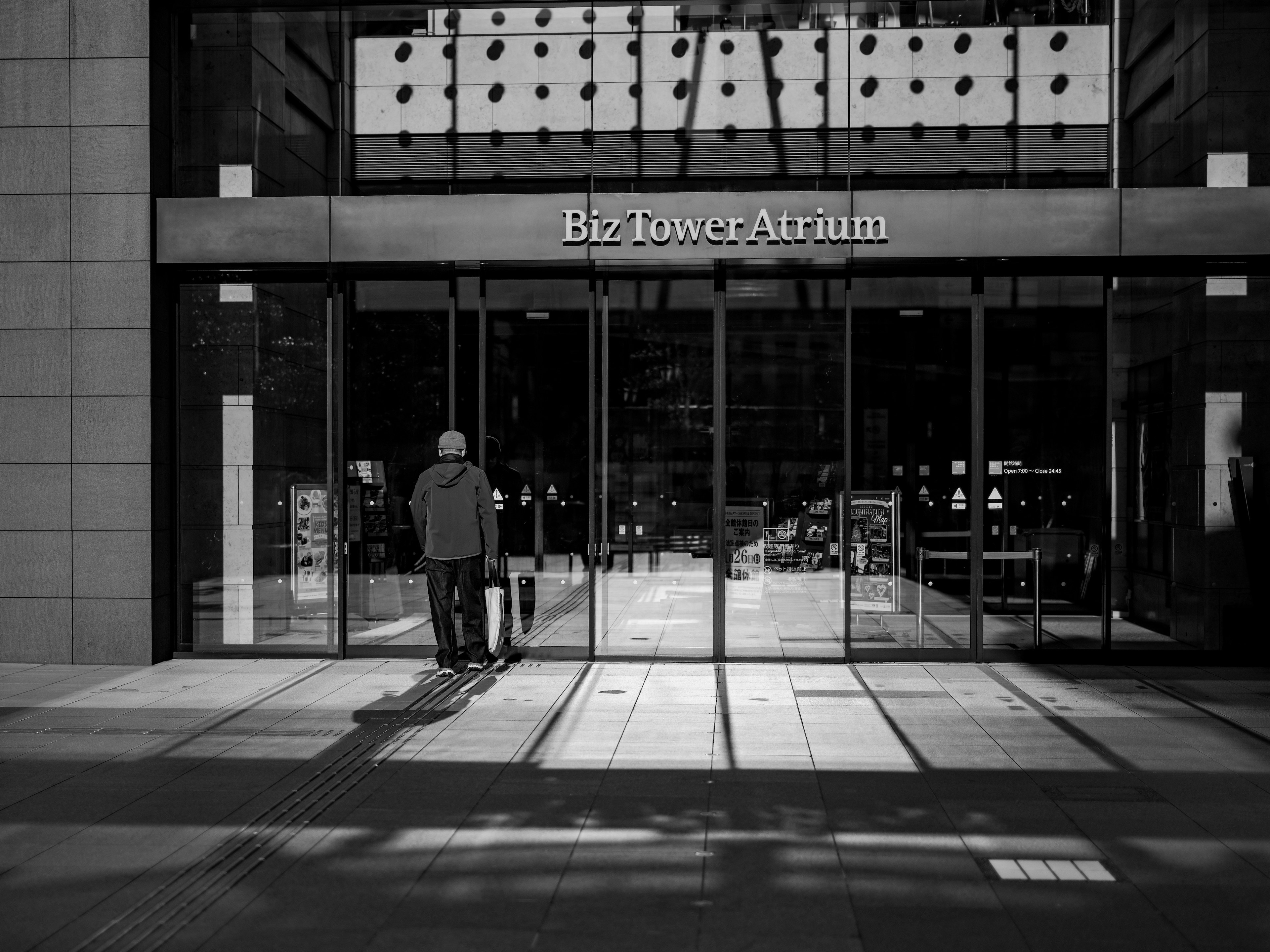 Black and white photo of people walking at the entrance of Biz Tower Atrium