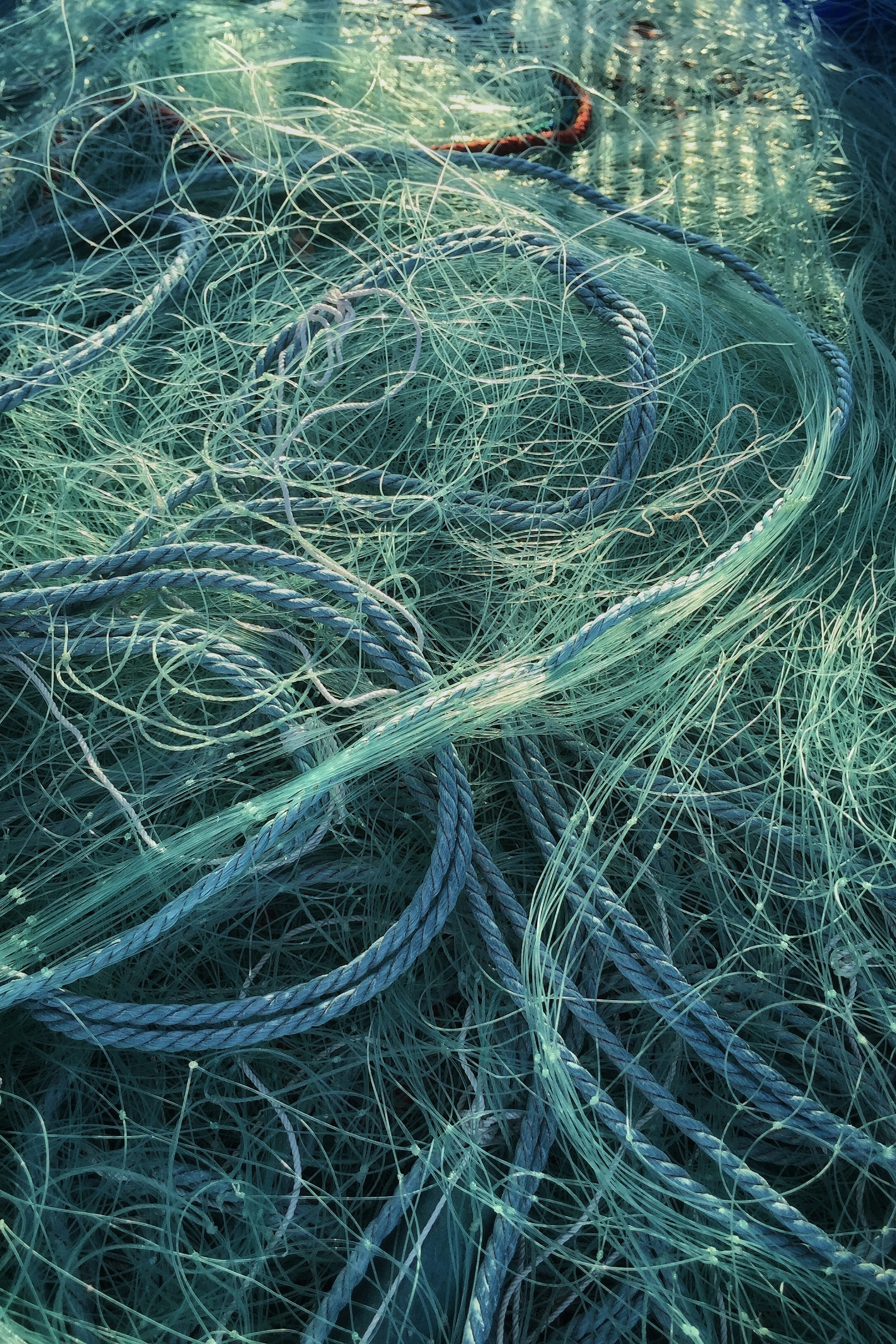 Tangled blue fishing nets in a disorganized pile