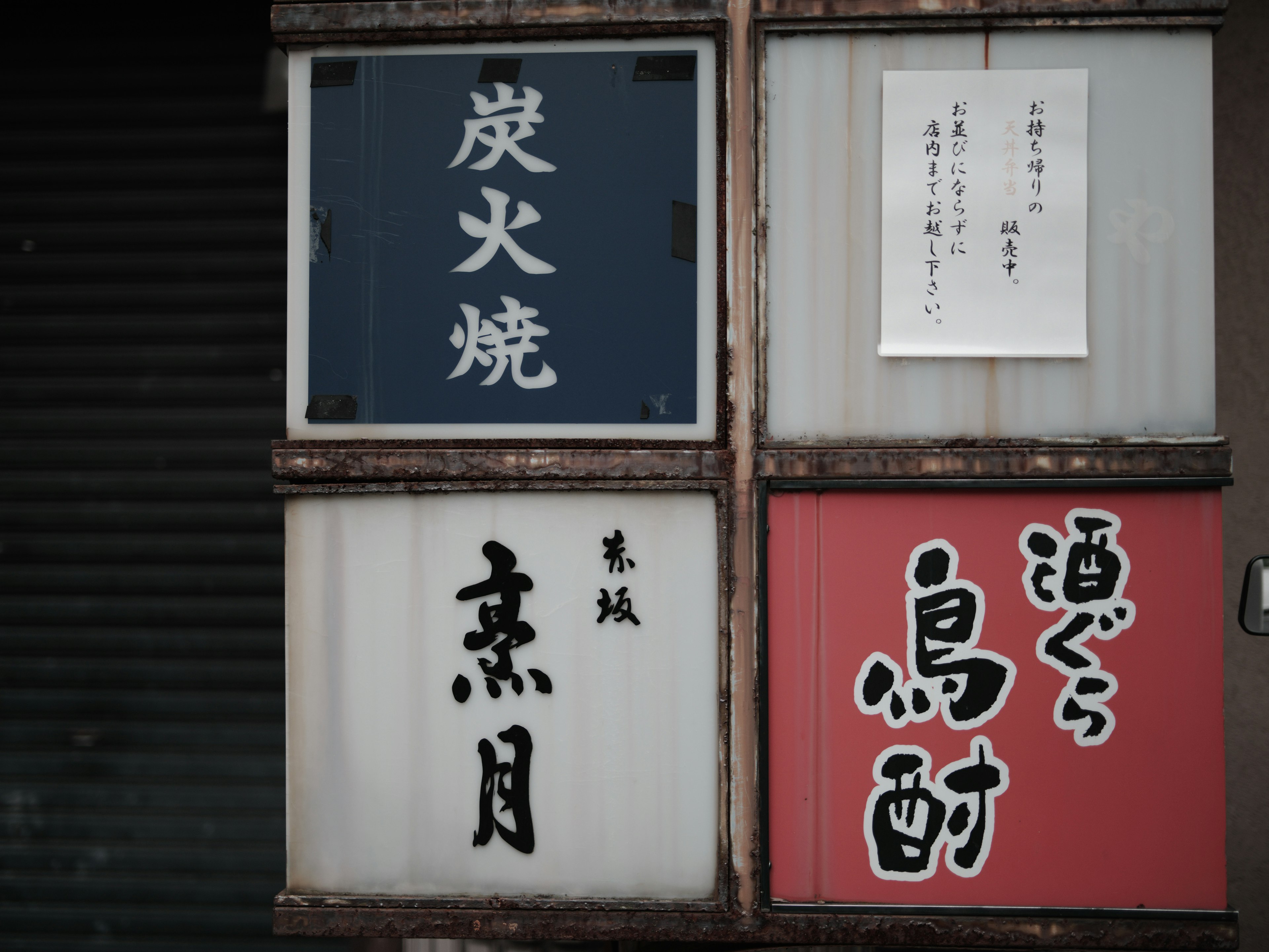 Esquina de la calle con letreros de un restaurante yakitori