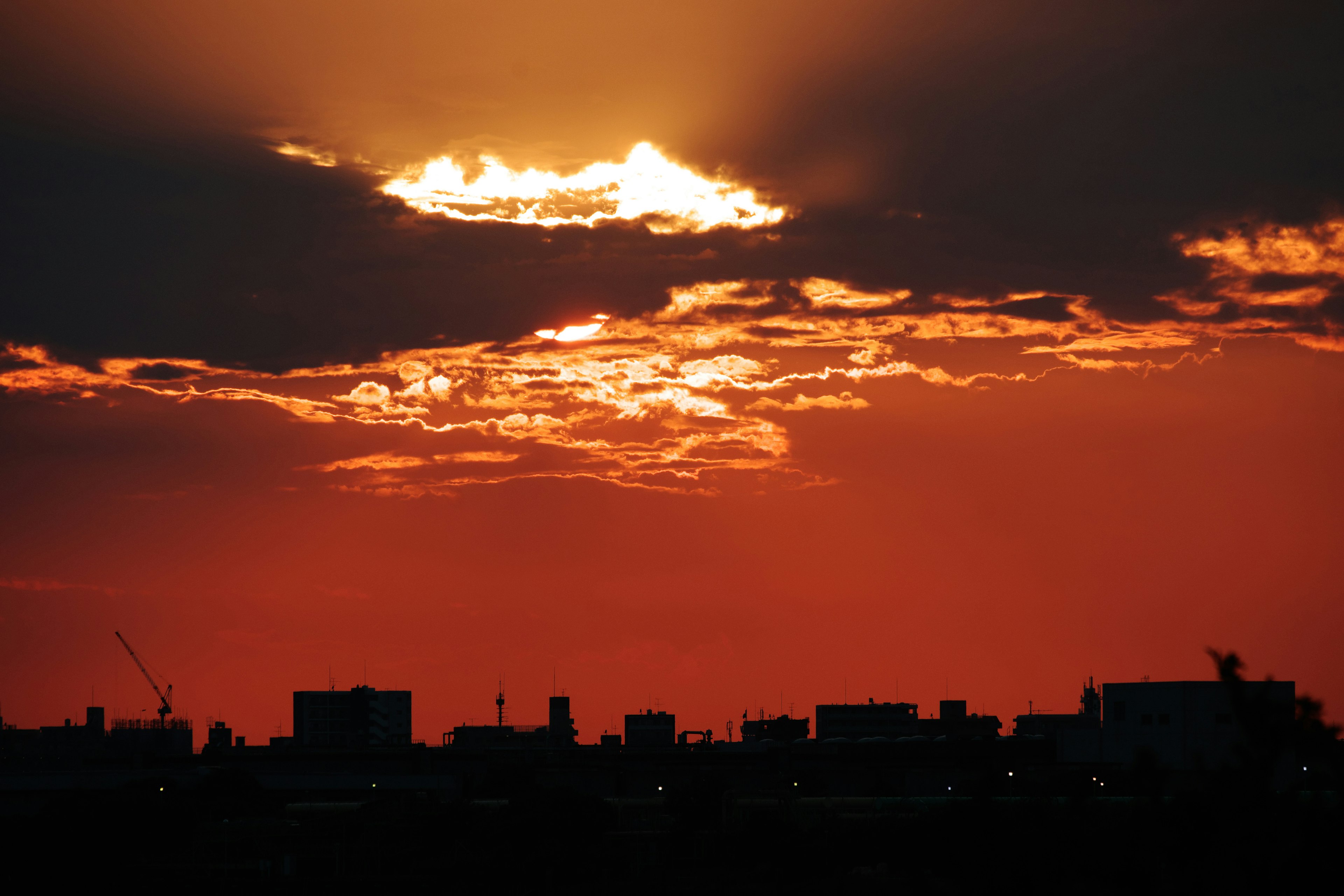 夕焼けの雲が広がる空とシルエットの都市