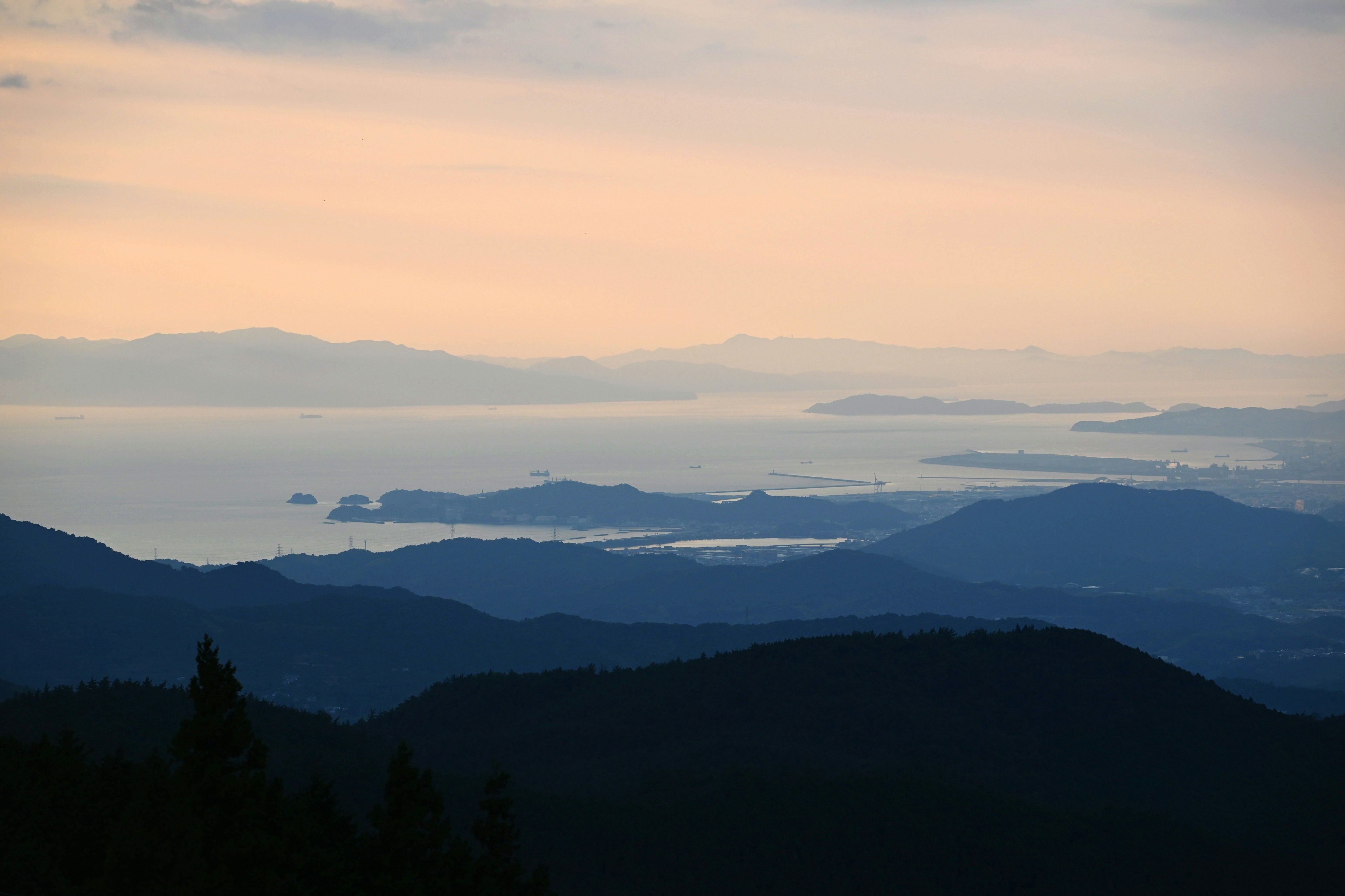 青い山脈と穏やかな海の景色が広がる風景