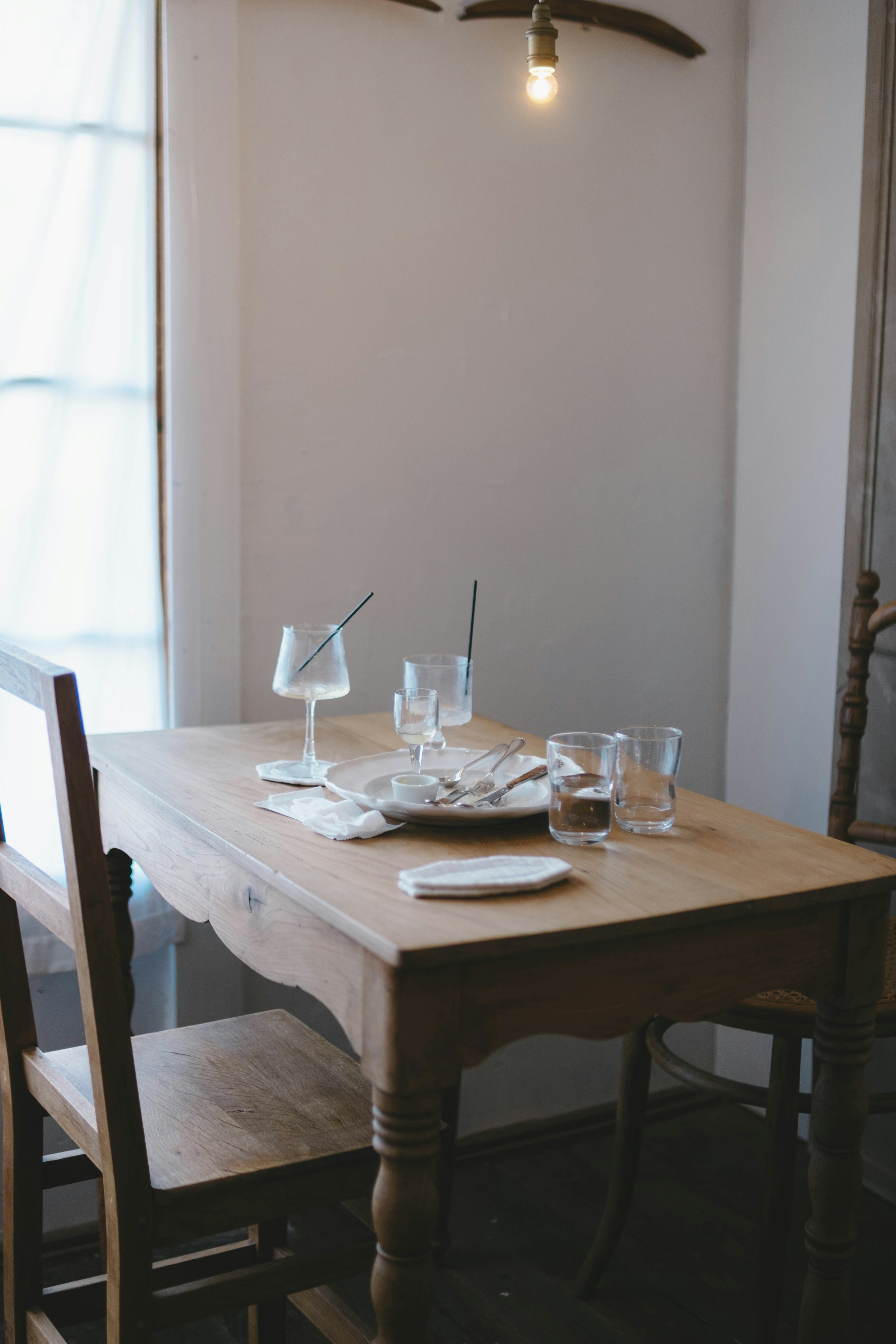 Una mesa de madera simple con sillas en un área de comedor