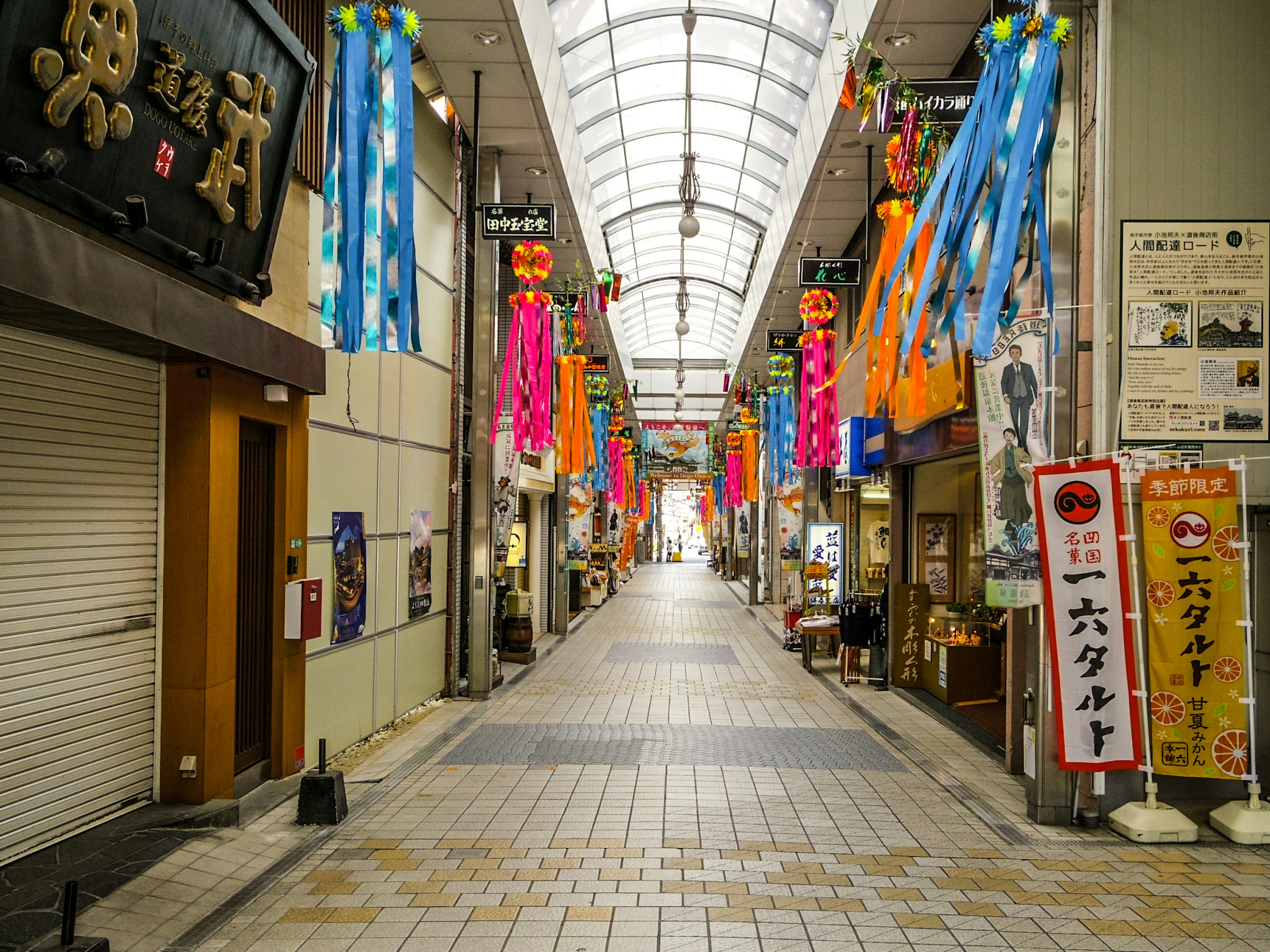 Una strada commerciale con decorazioni colorate appese al soffitto