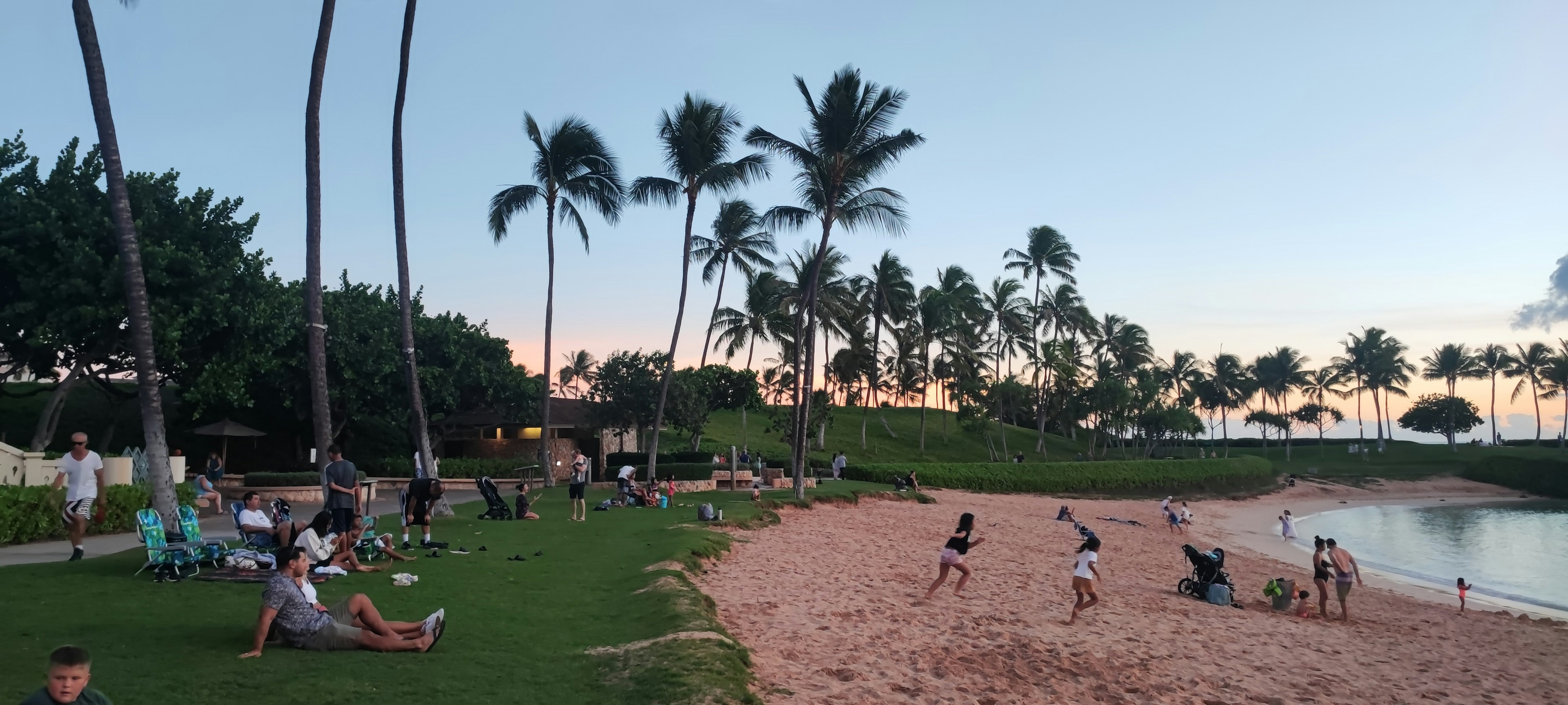 Scena di spiaggia al tramonto con bambini che giocano e palme