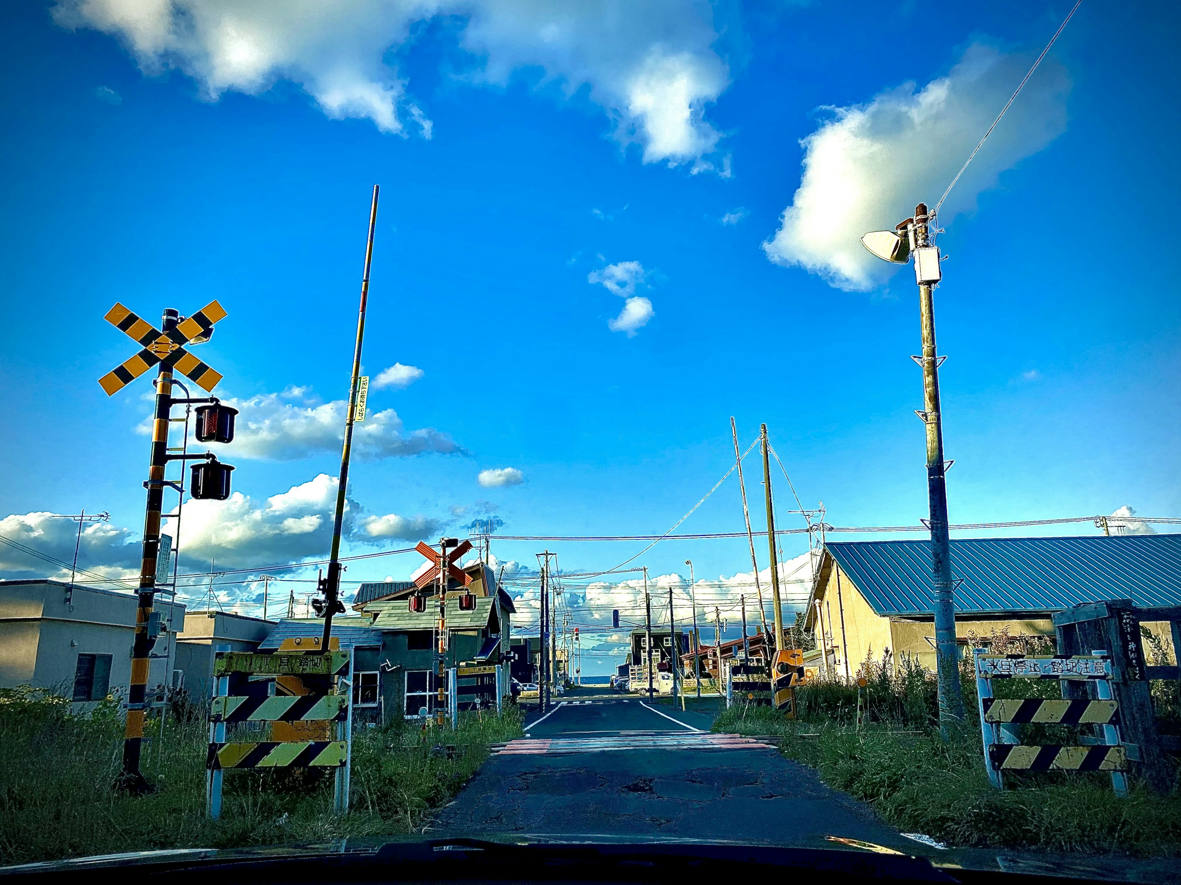 ทางรถไฟใต้ท้องฟ้าสีฟ้ากับเมฆขาวและอาคารรอบข้าง