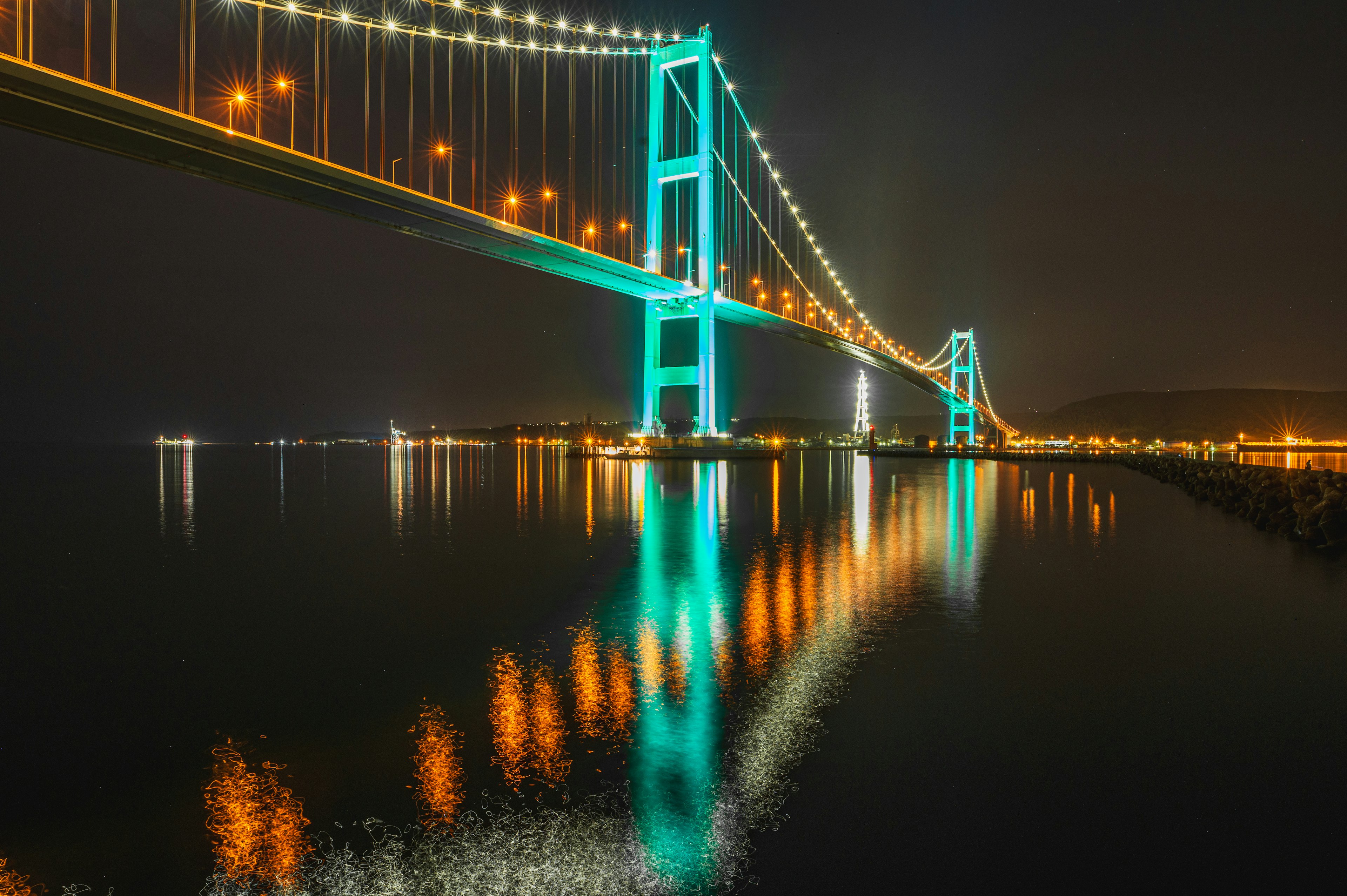 Ponte illuminato di notte con riflessi nell'acqua