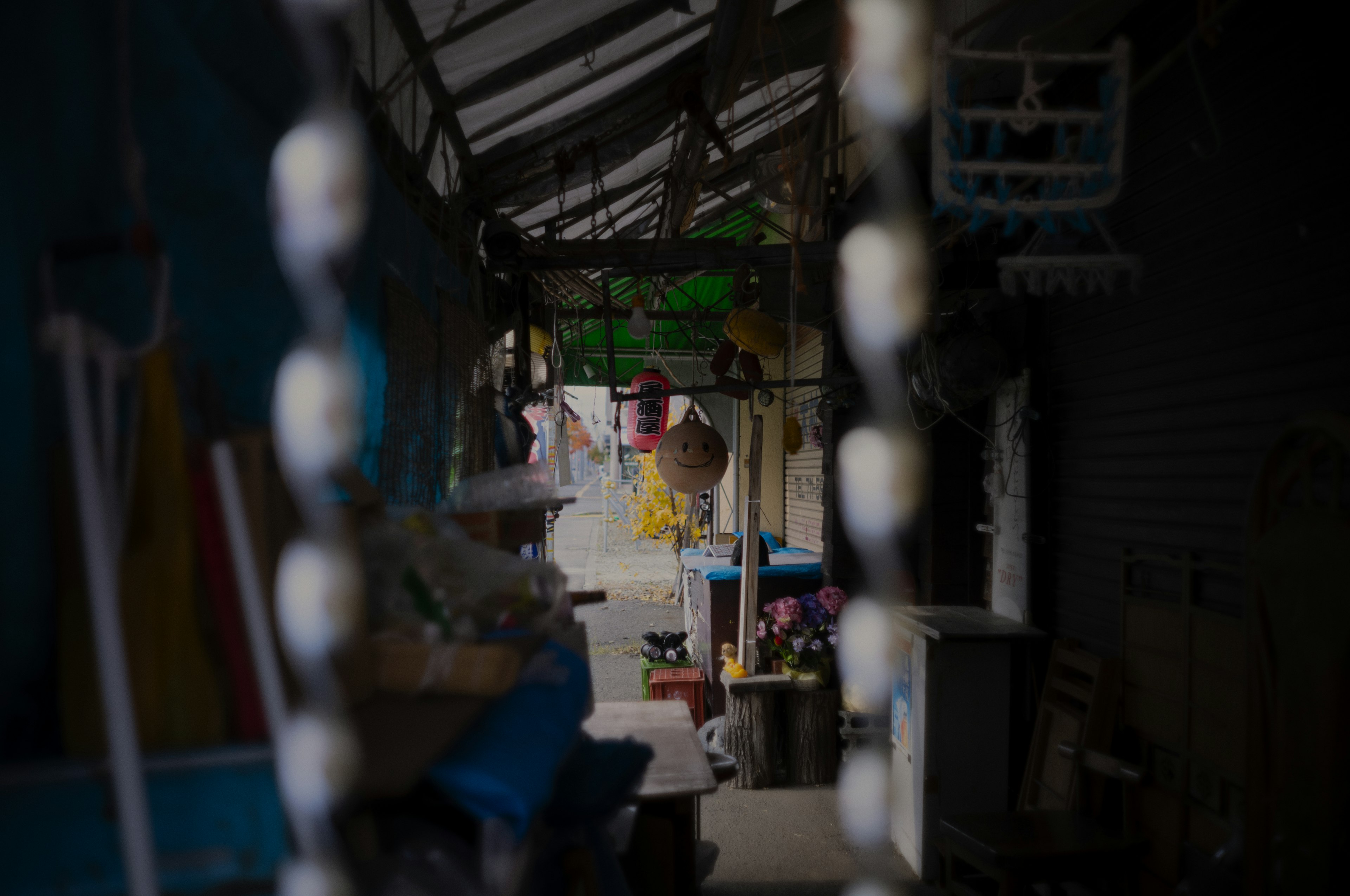 Narrow passageway with hanging decorations and colorful shops visible