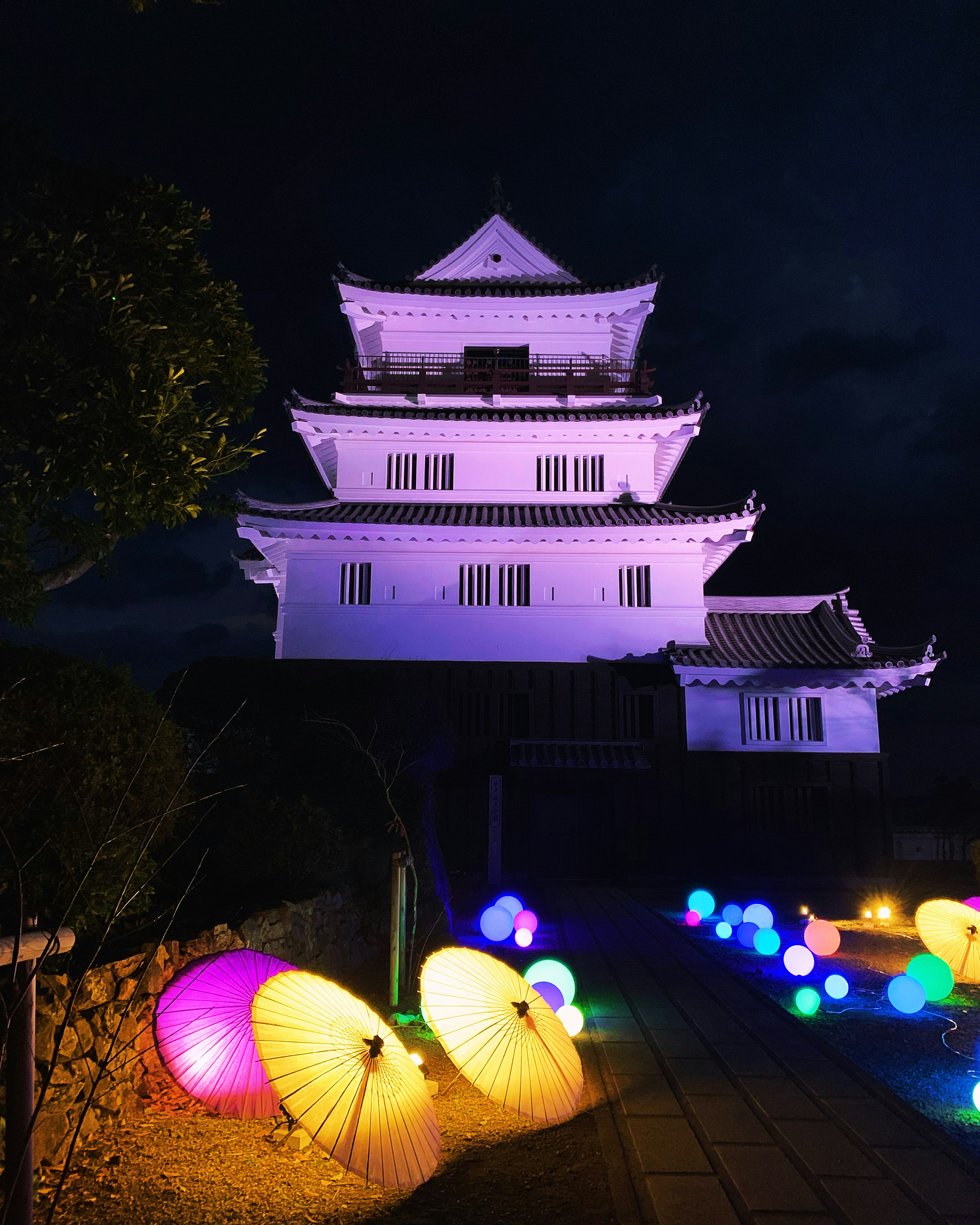 夜に照らされた美しい城とカラフルな傘の飾り