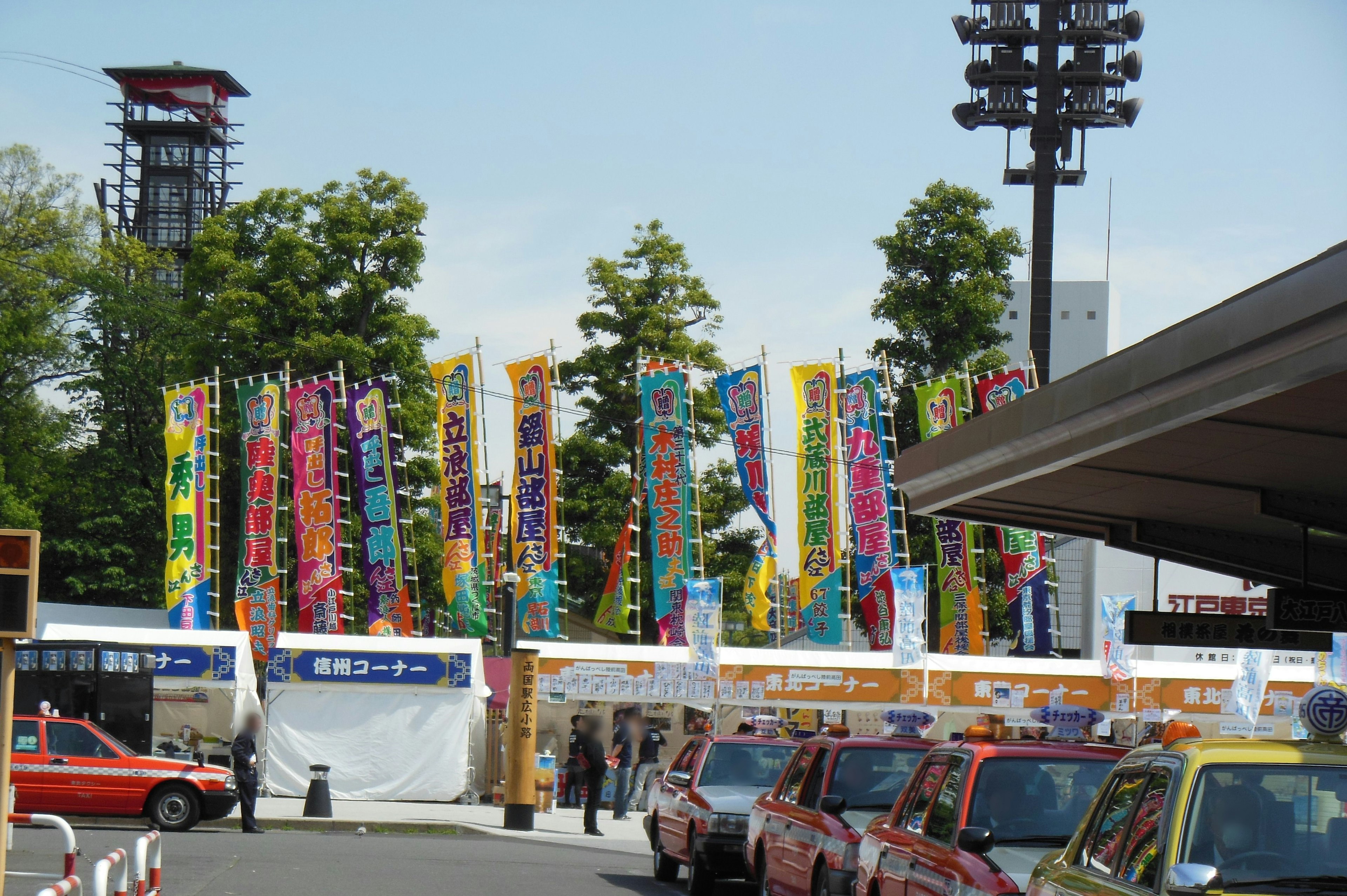 Festivalgelände mit bunten Fahnen und roten Taxis