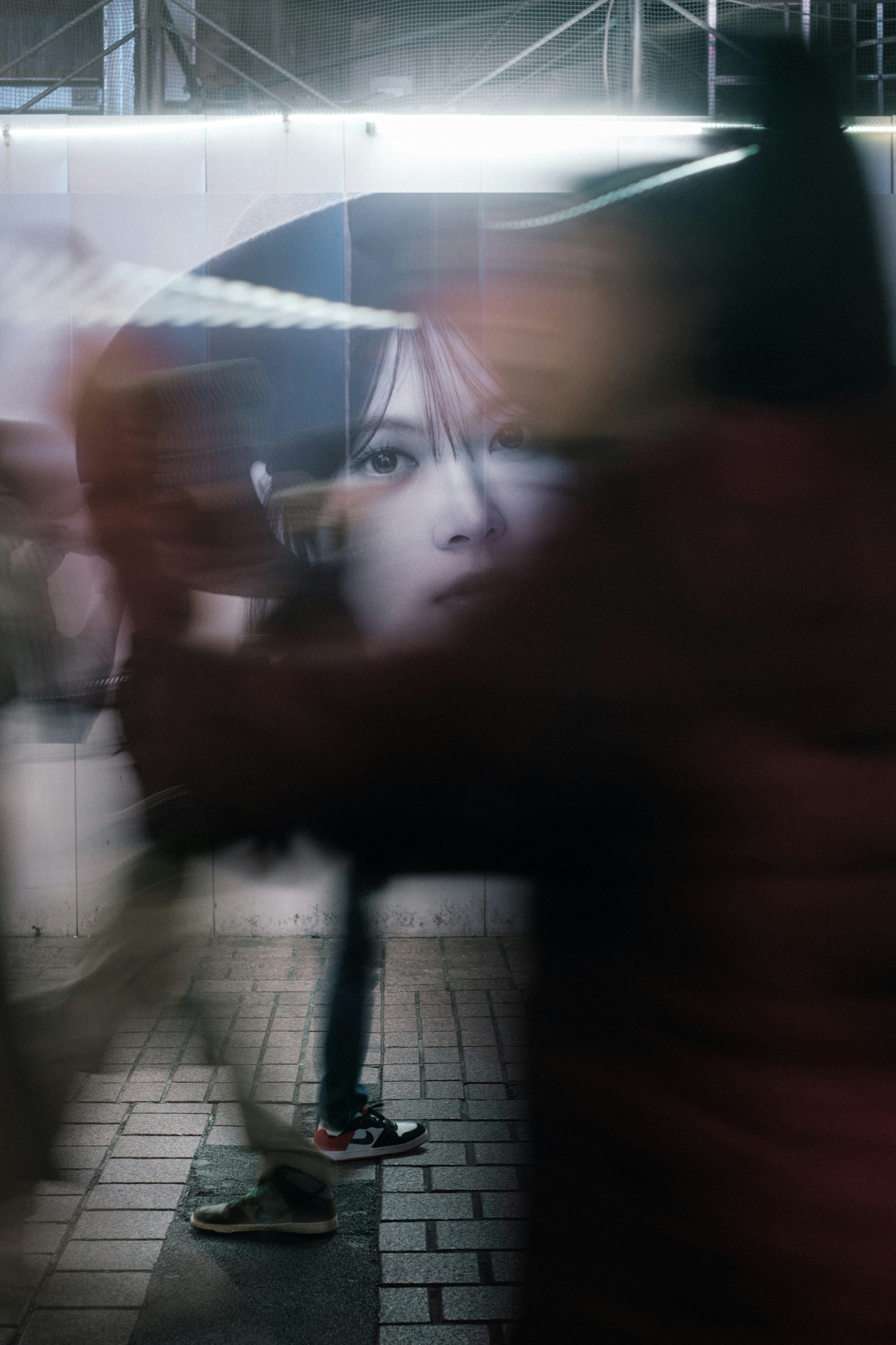 Large face advertisement partially obscured by passing pedestrians