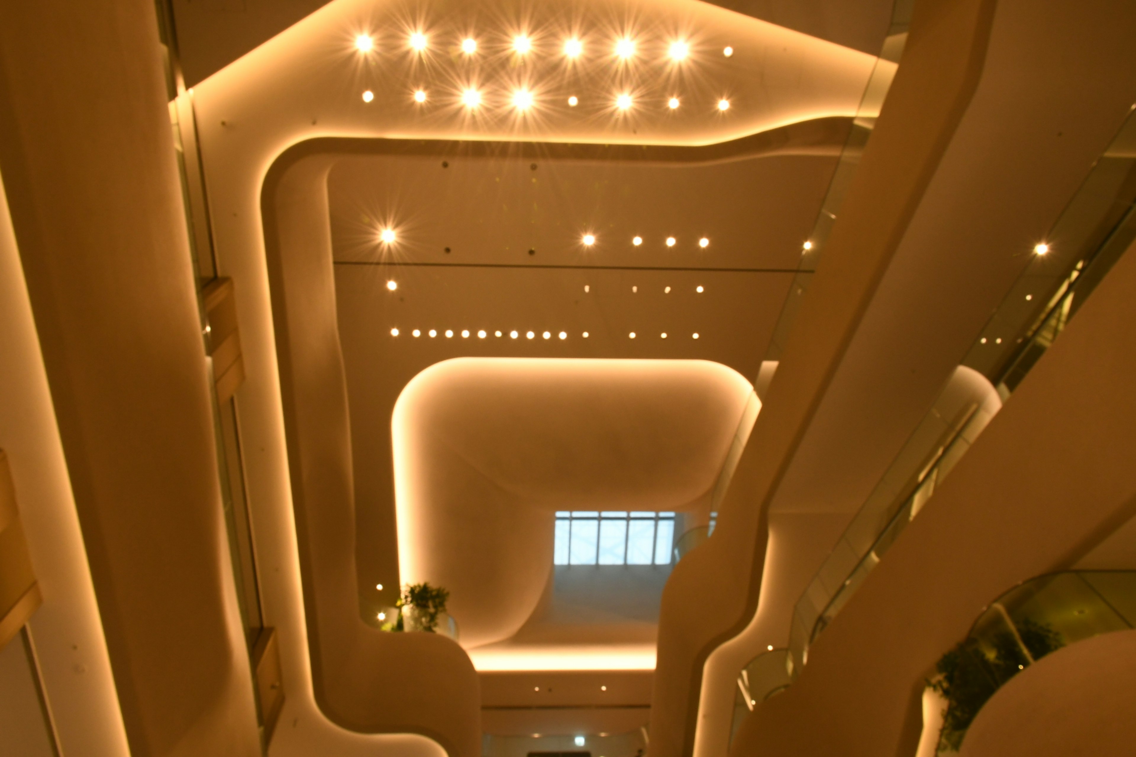 Diseño interior de un edificio moderno con escaleras curvas y luz cálida