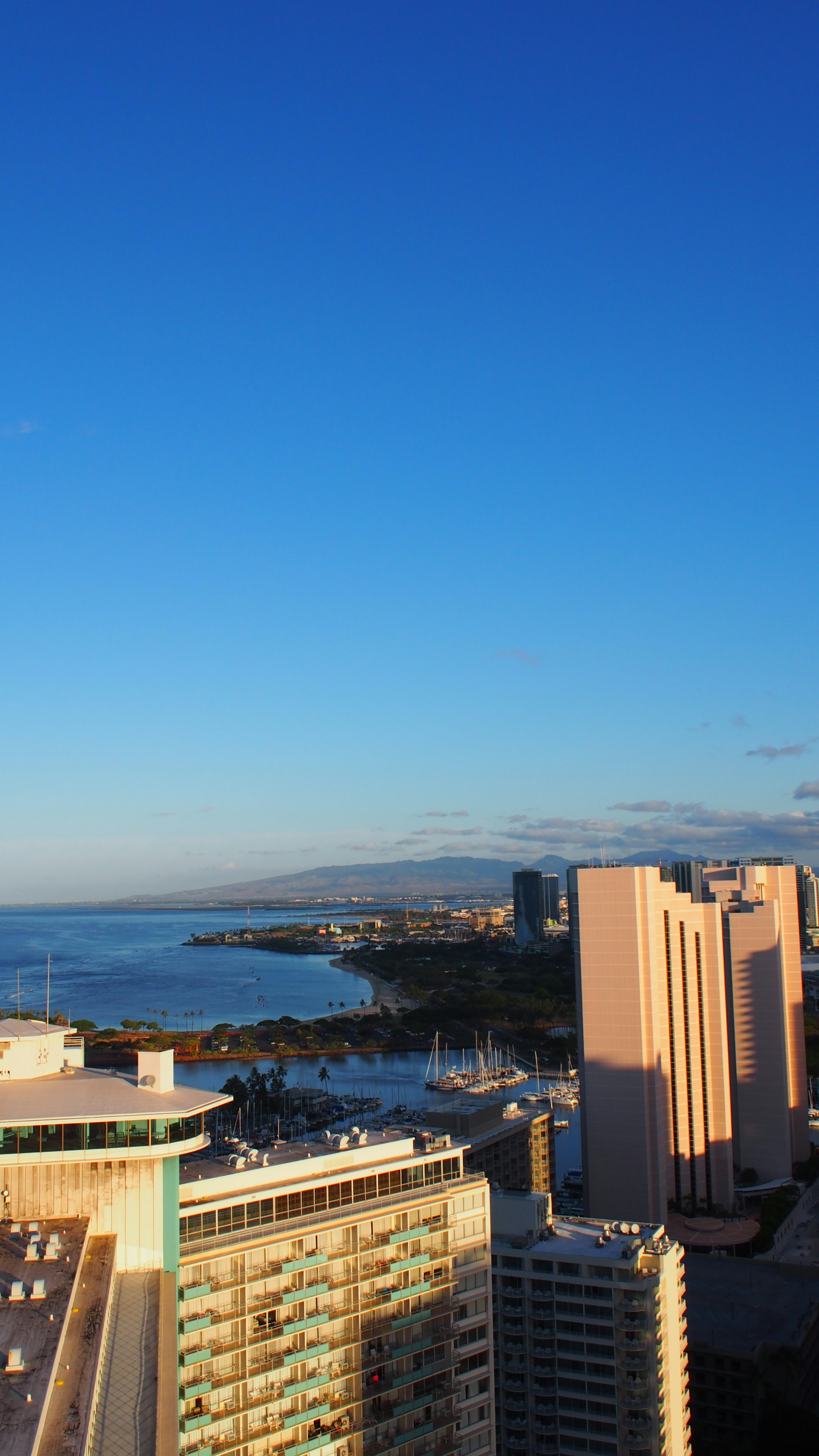 Panoramic view of tall buildings near a blue ocean under a clear sky