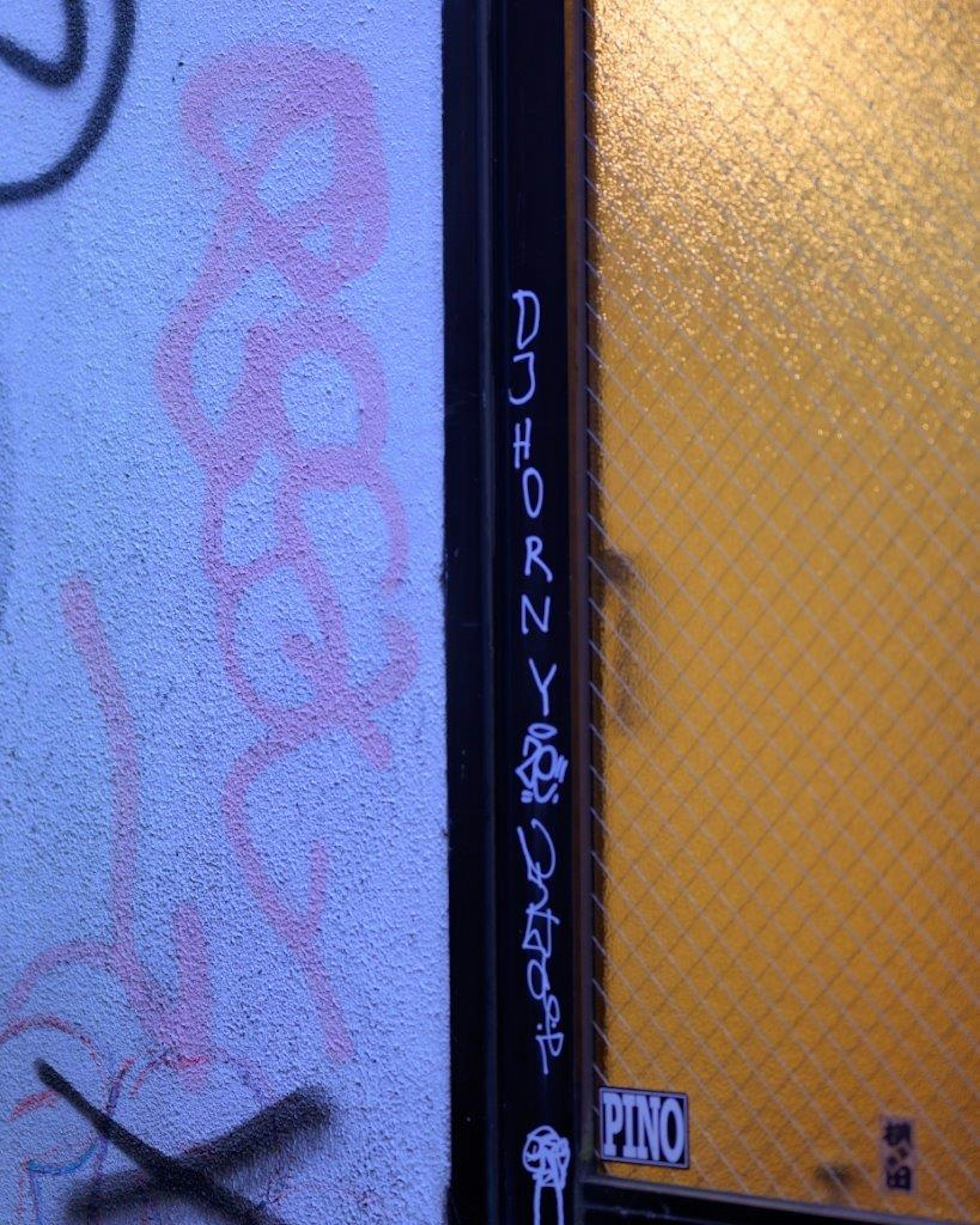 Graffiti sur un mur près d'une fenêtre jaune avec le tag DJ HORNY