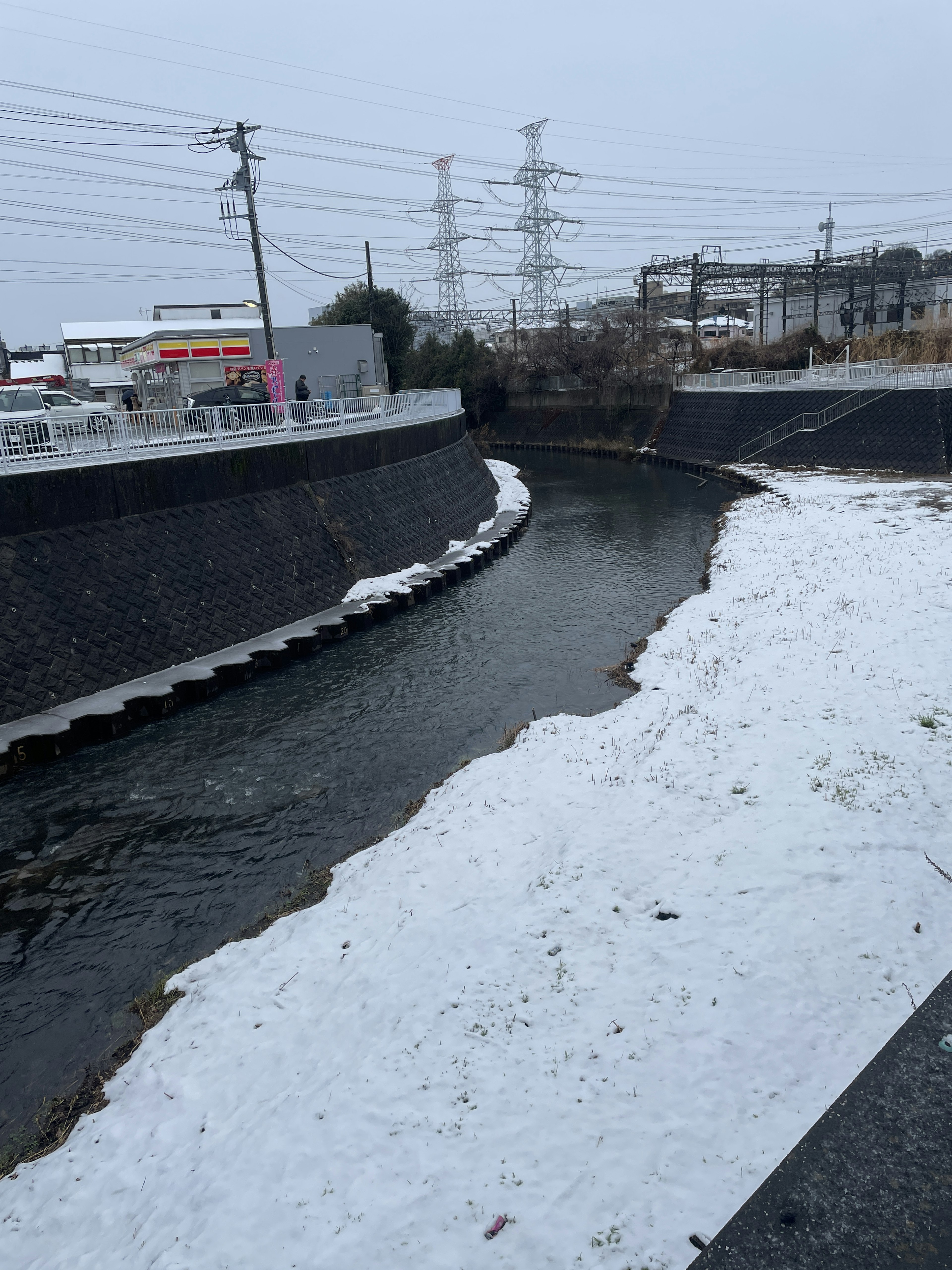 A snowy river landscape with surrounding buildings