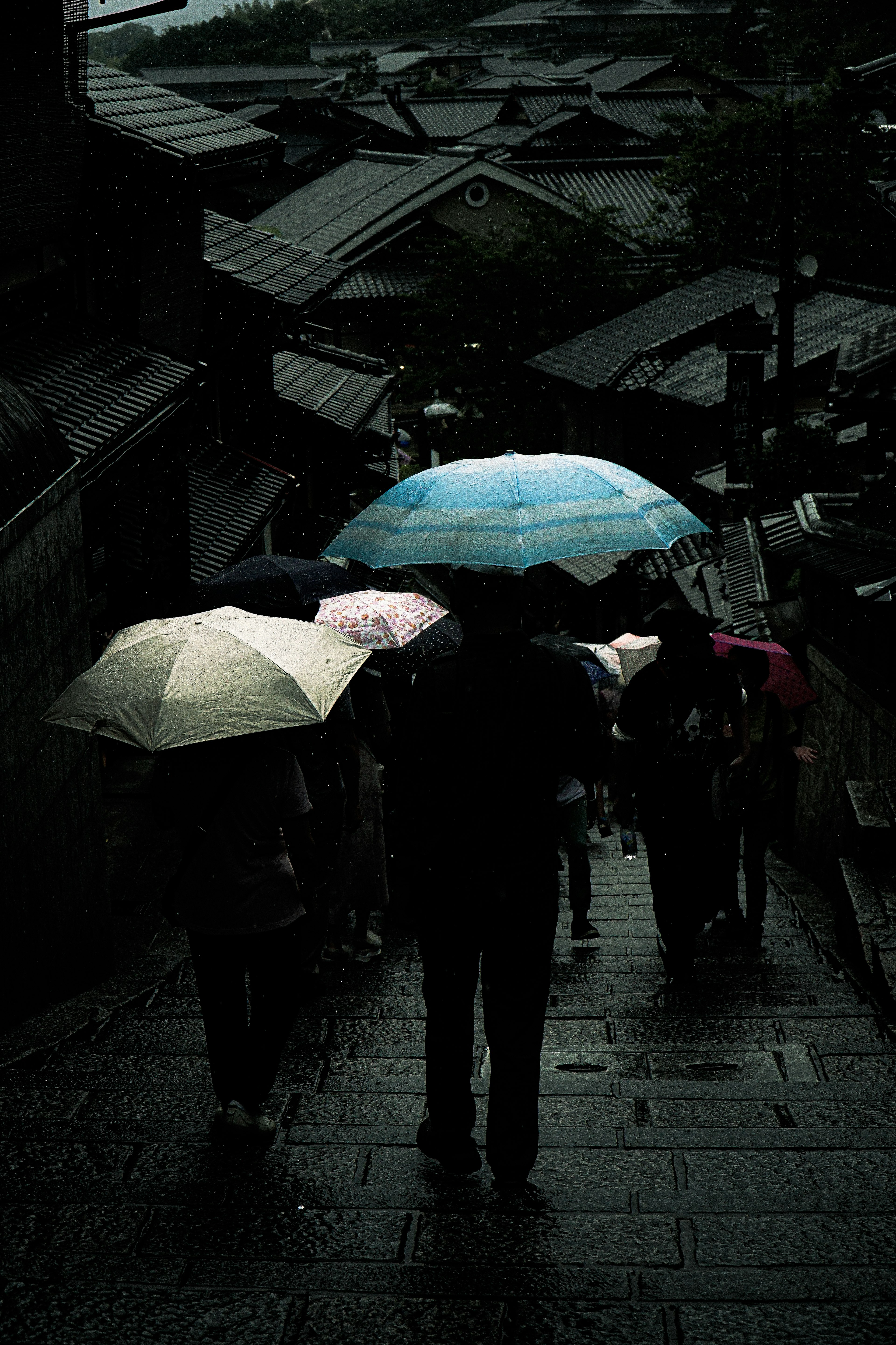 人們在雨中撐著傘走在街道上