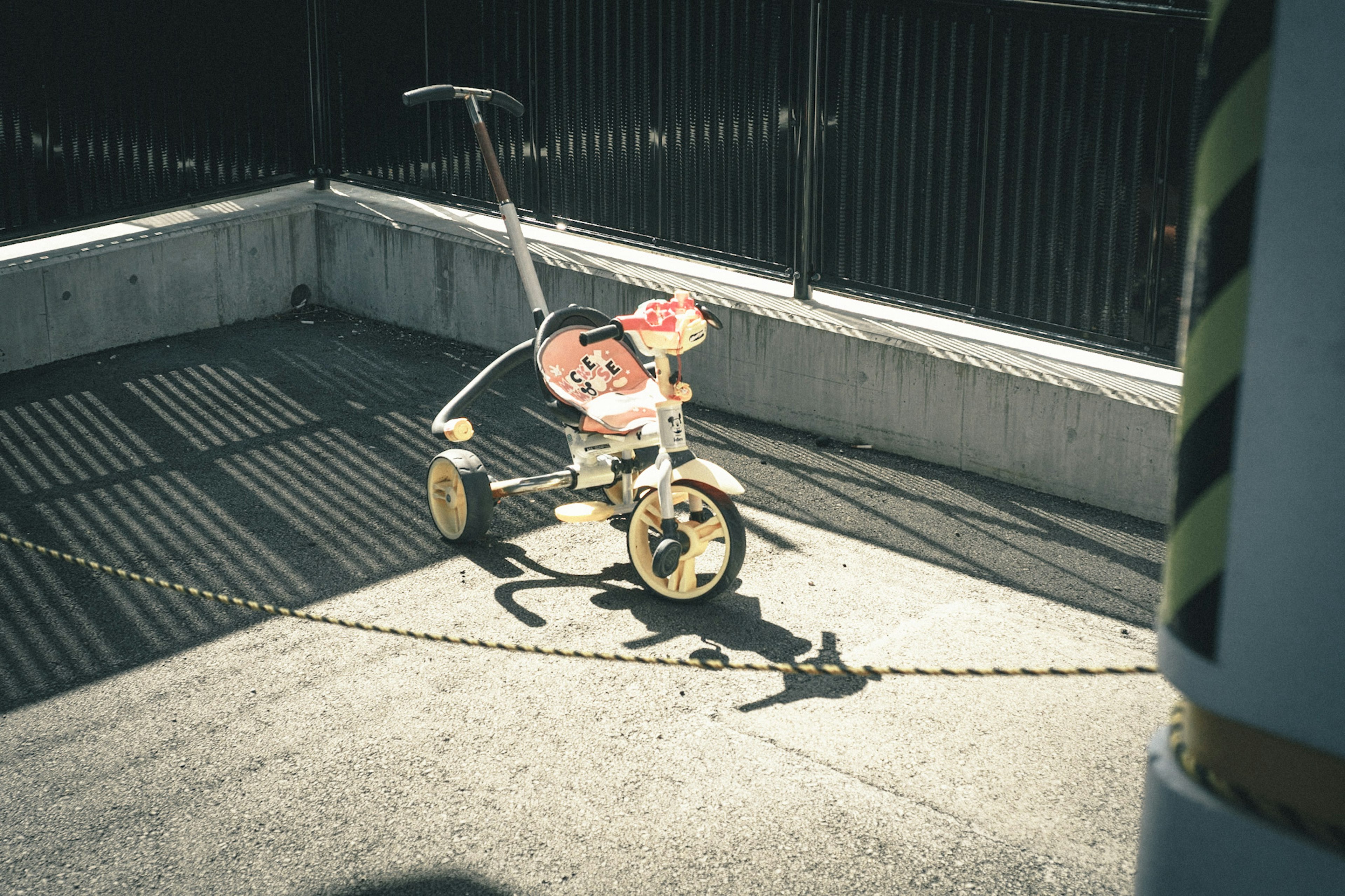 A tricycle left in an empty corner with shadows