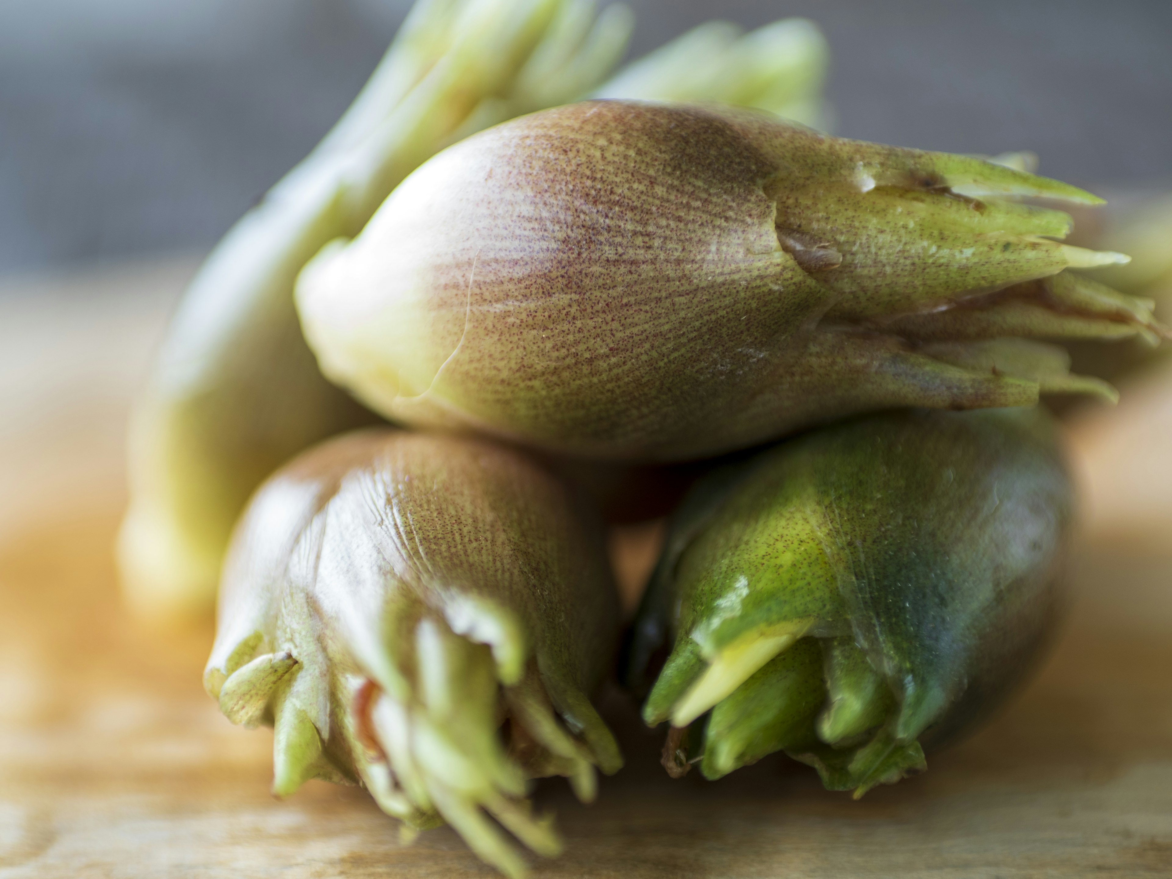 Racines de gingembre frais disposées sur une planche en bois