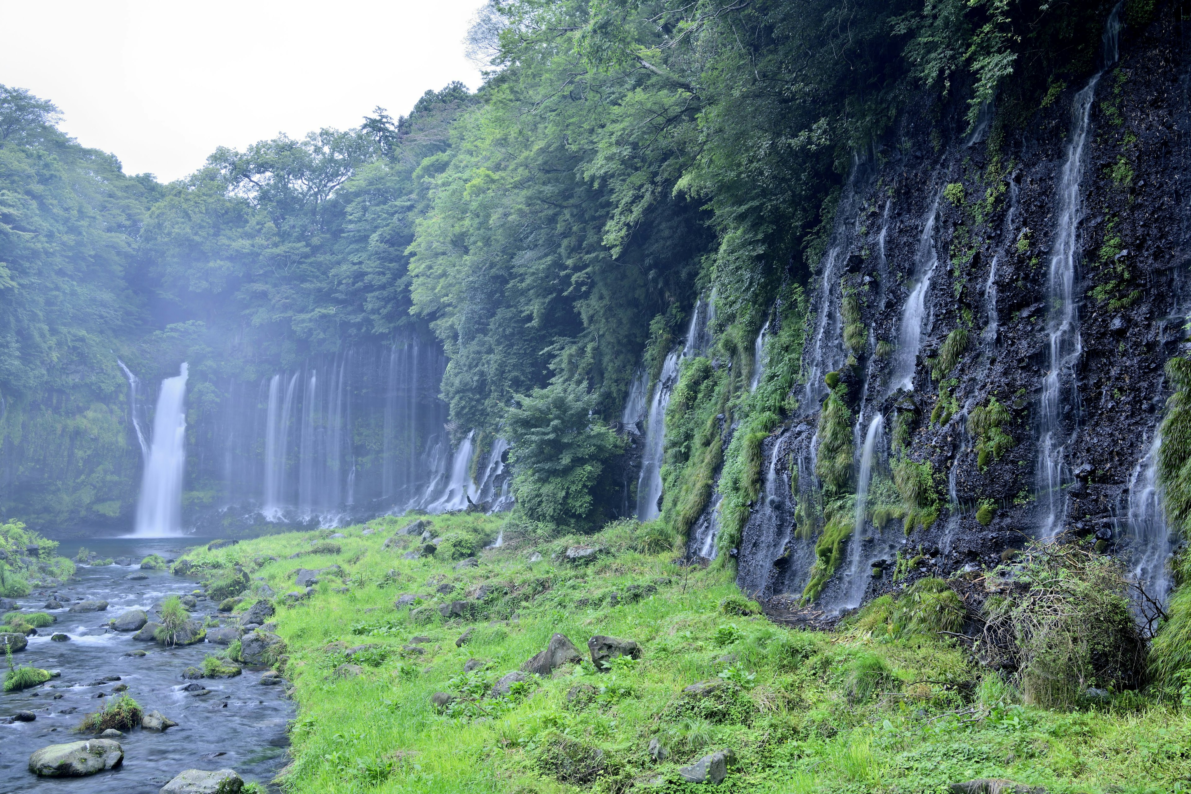 Lush green landscape with waterfalls flowing