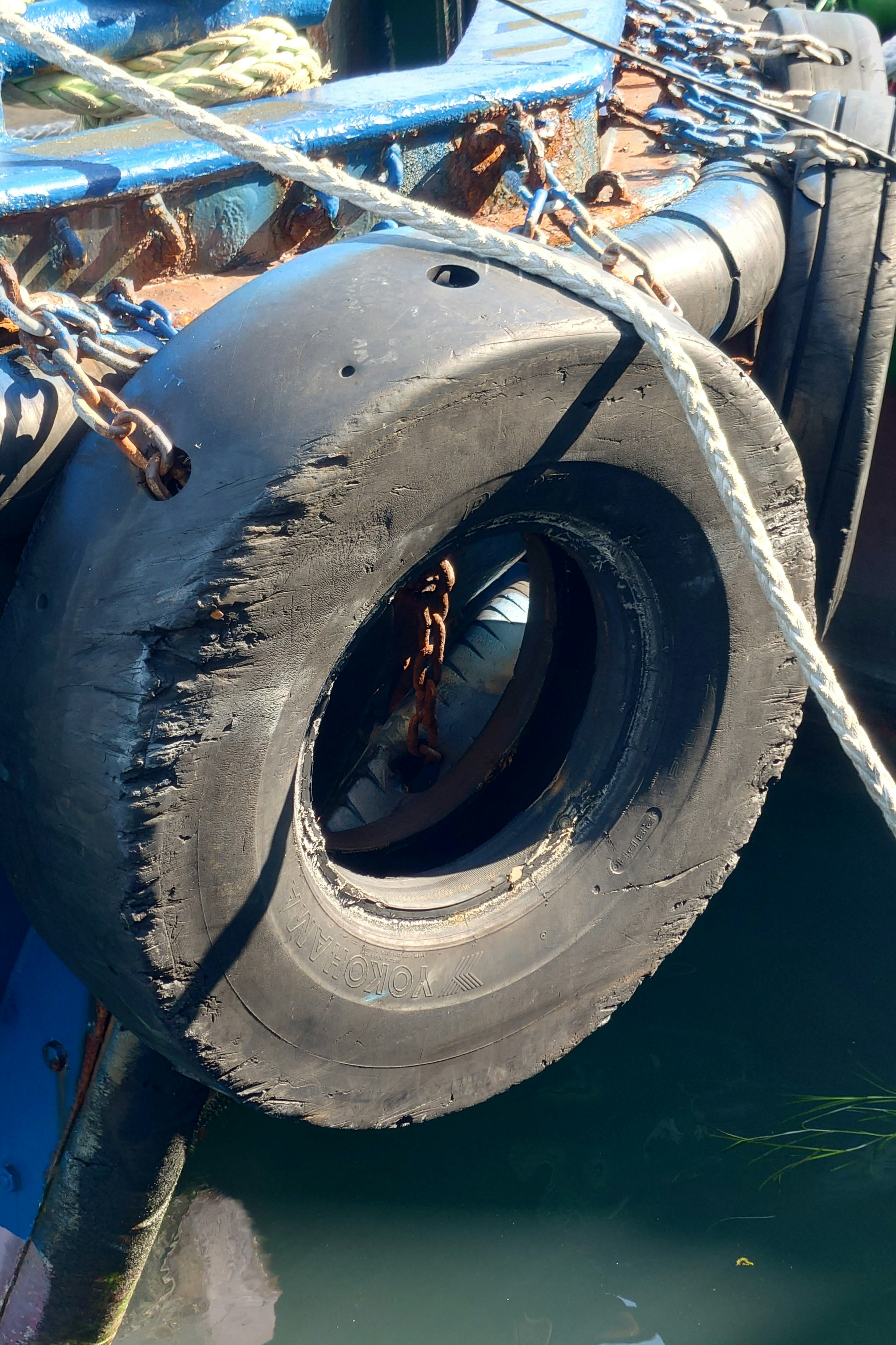 Close-up of a worn tire fender on a boat