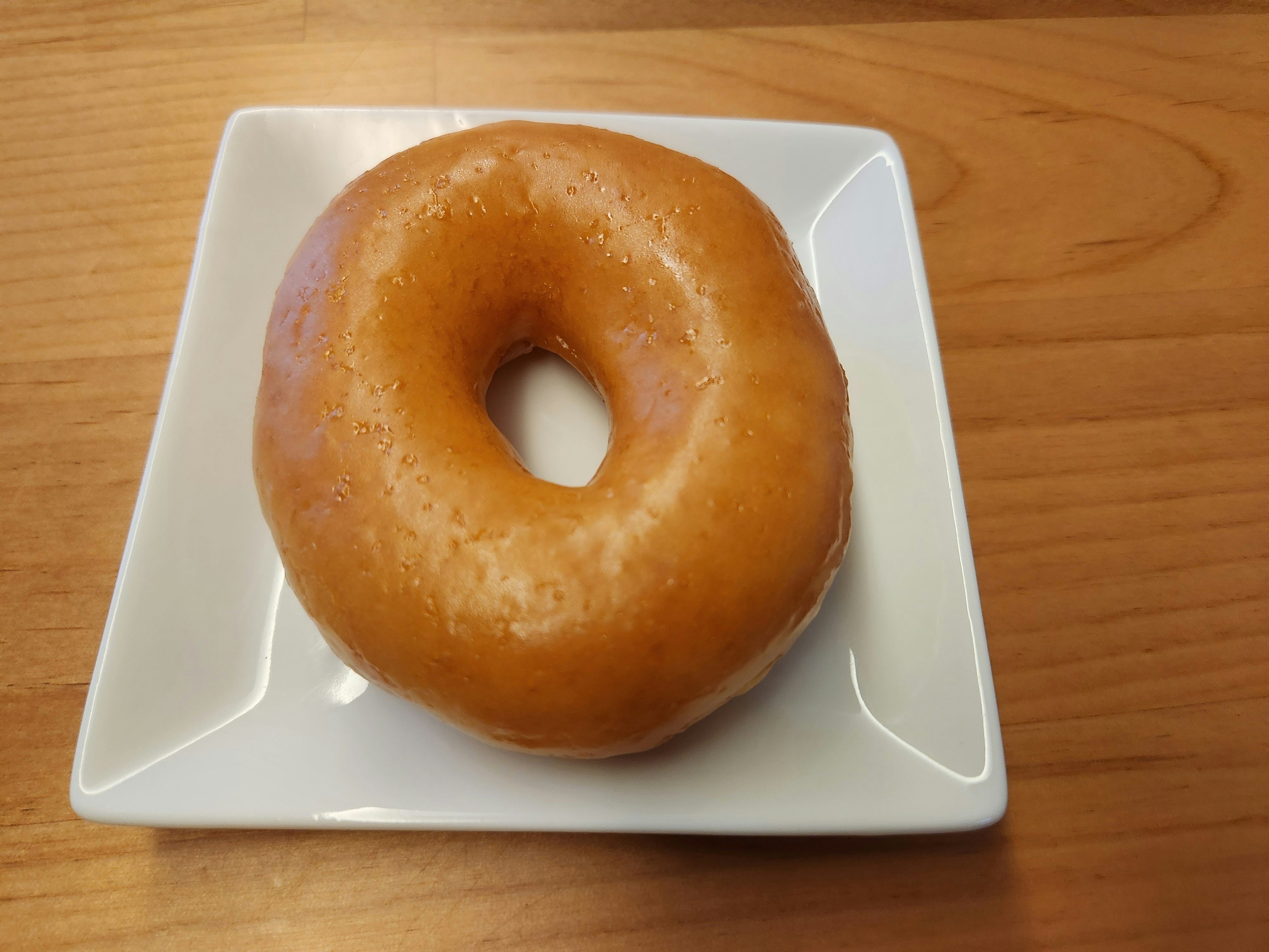 Una deliziosa ciambella glassata su un piatto bianco