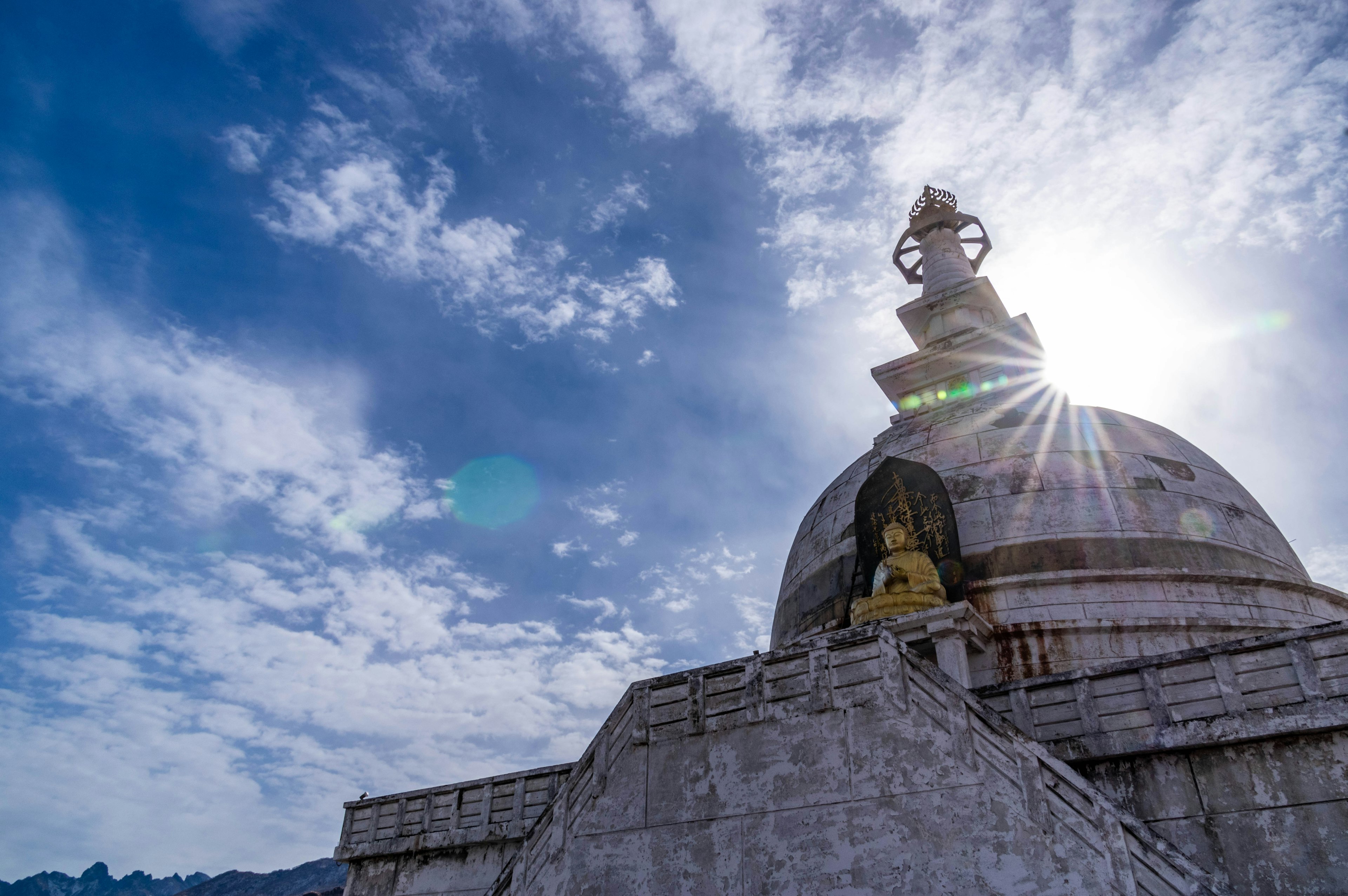 Beautiful stupa under a blue sky with a shining sun in the background