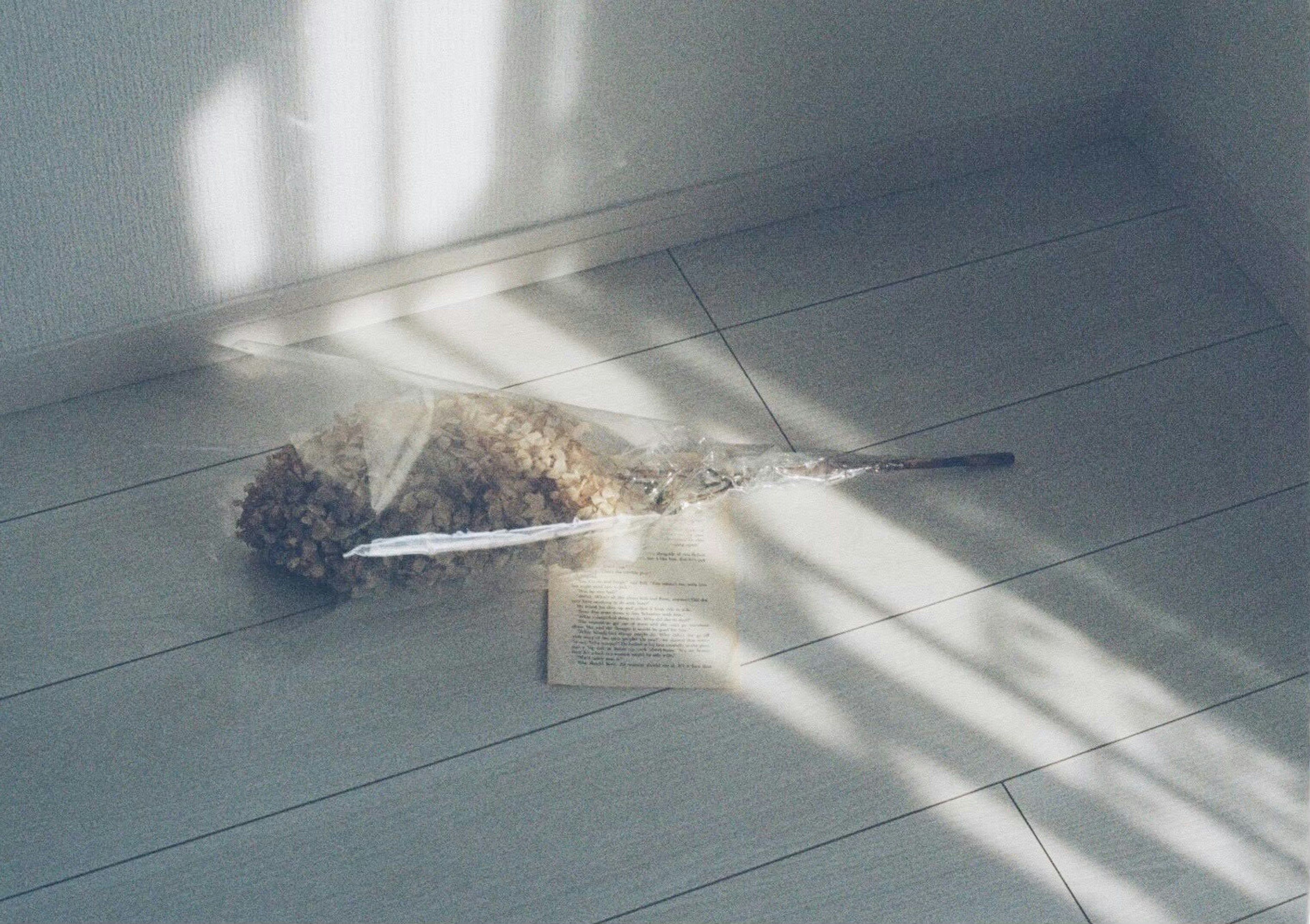 Una escoba descansando en el suelo con sombras de luz