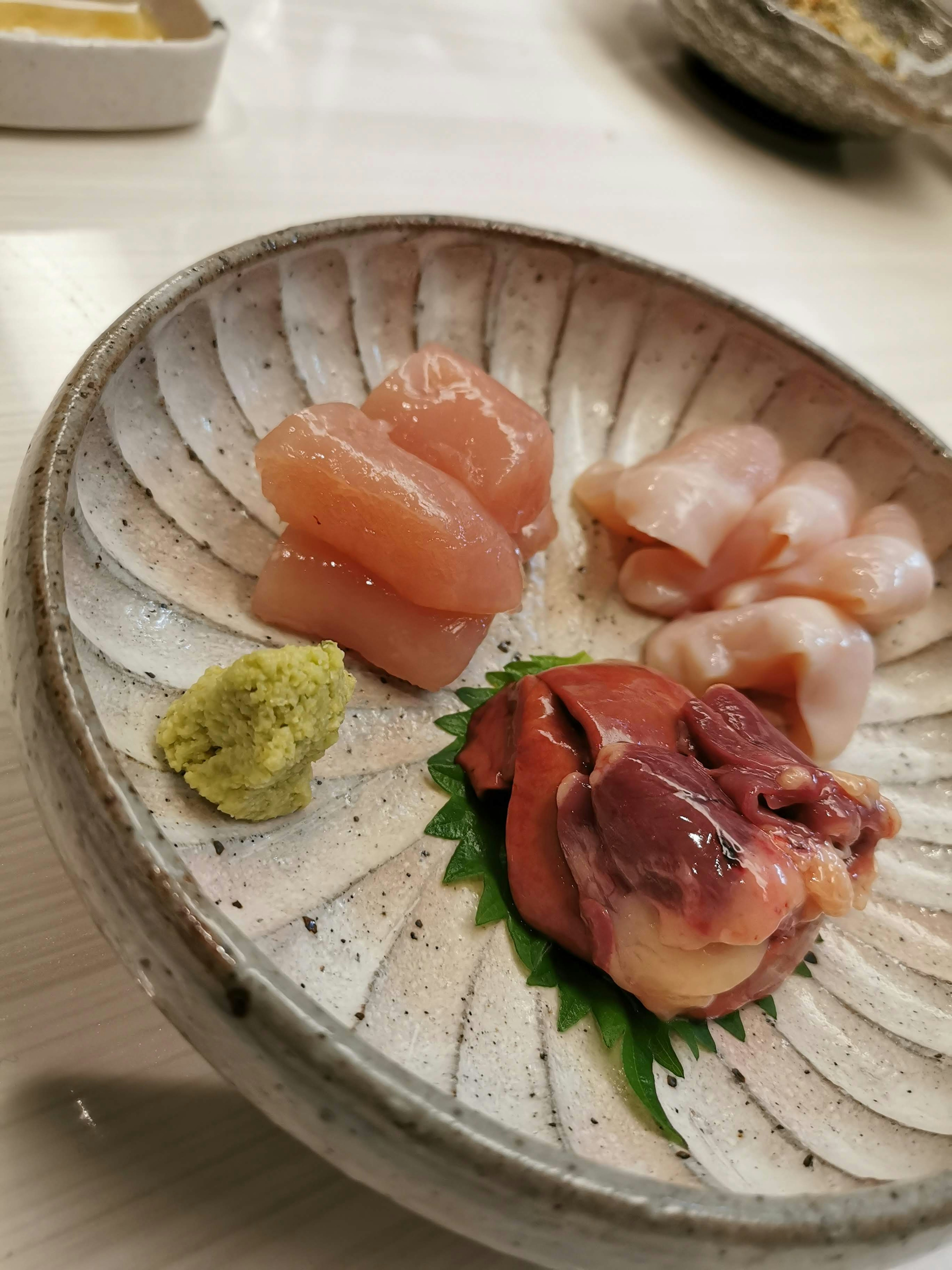 Surtido de sashimi bellamente presentado en un plato de cerámica