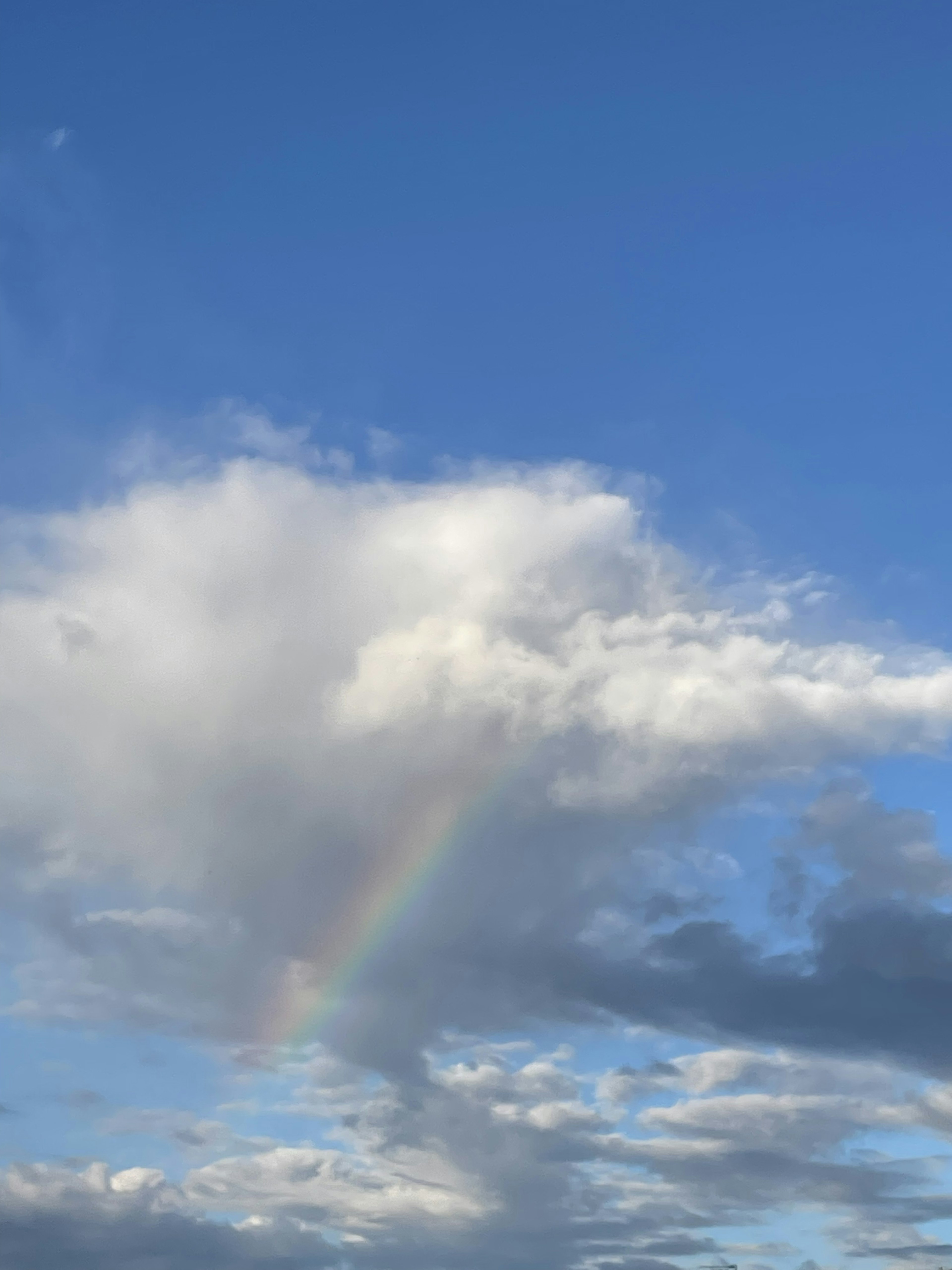 Awan putih dan pelangi di langit biru