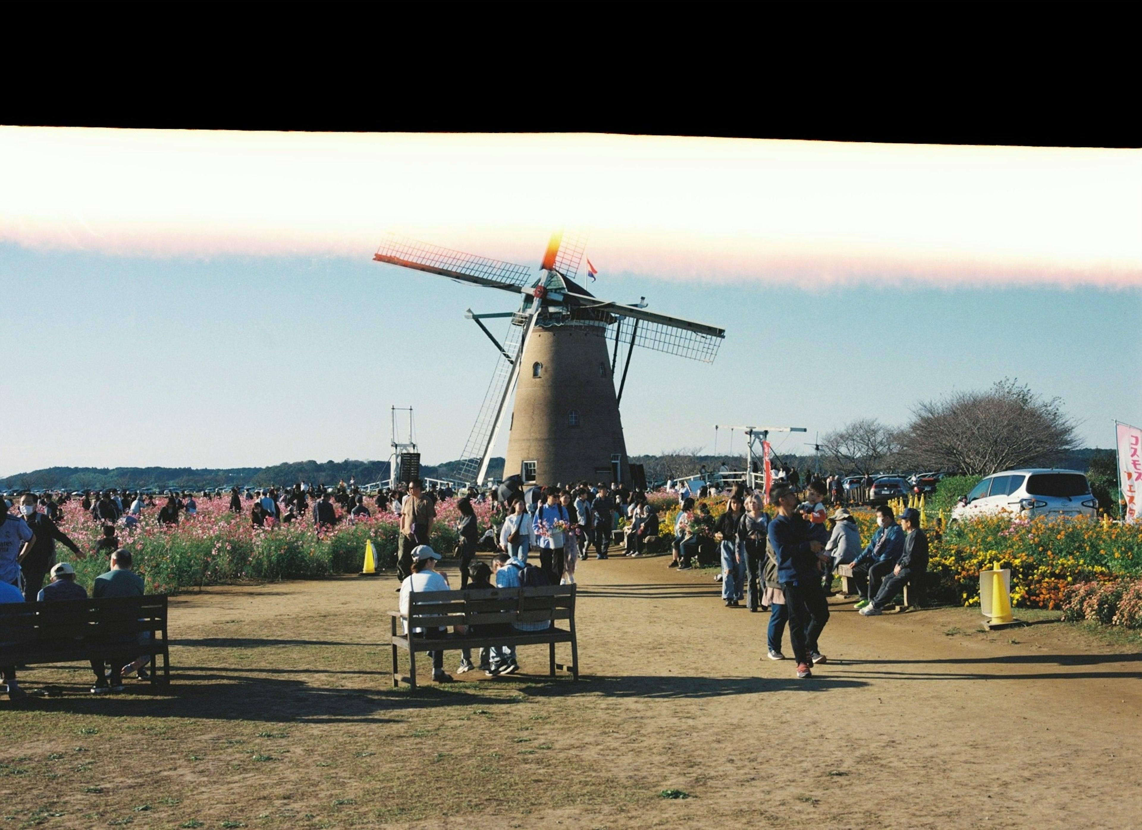 風車の周りに人々が集まる風景