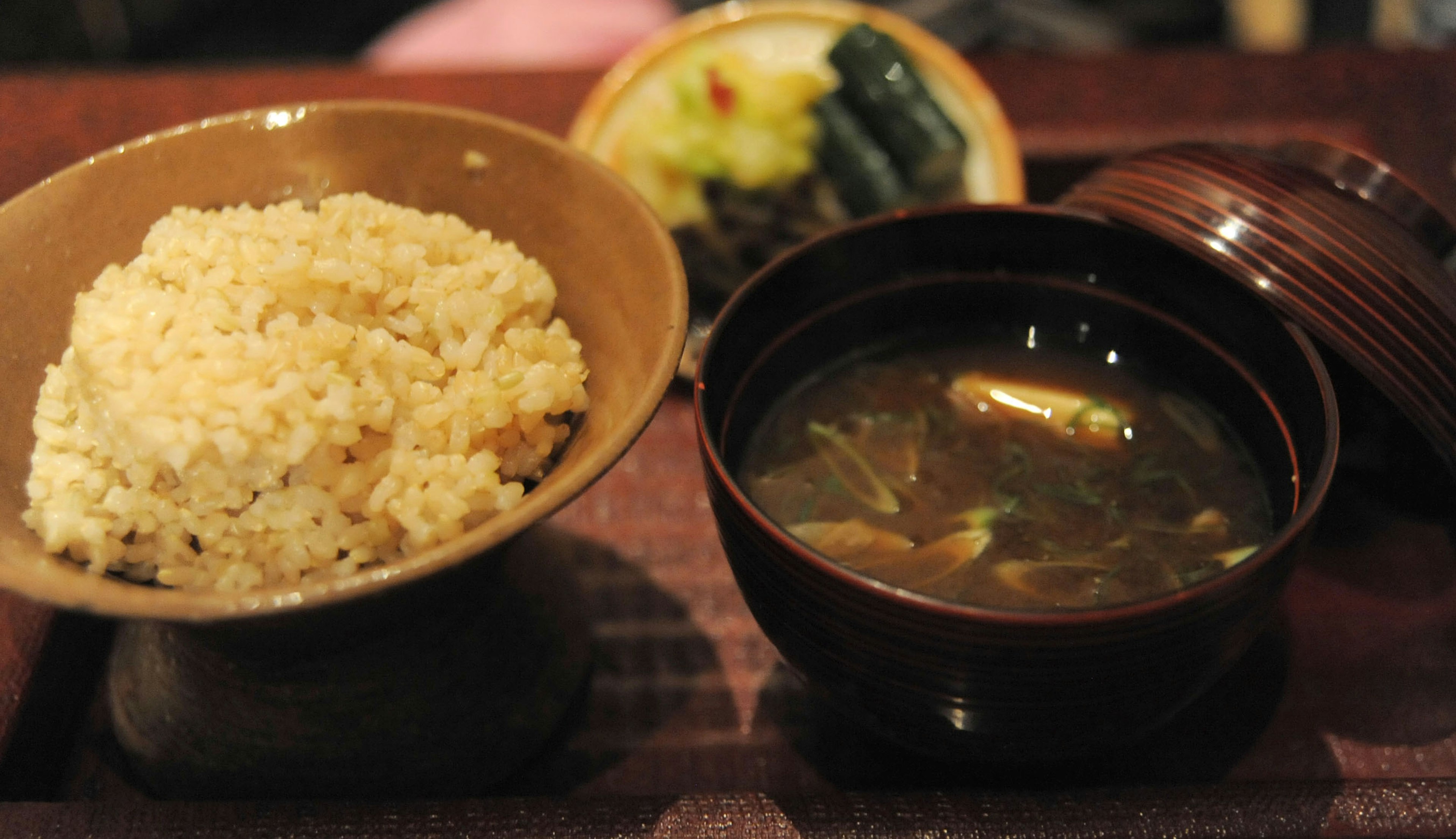 Bowl of brown rice and miso soup served on a wooden tray