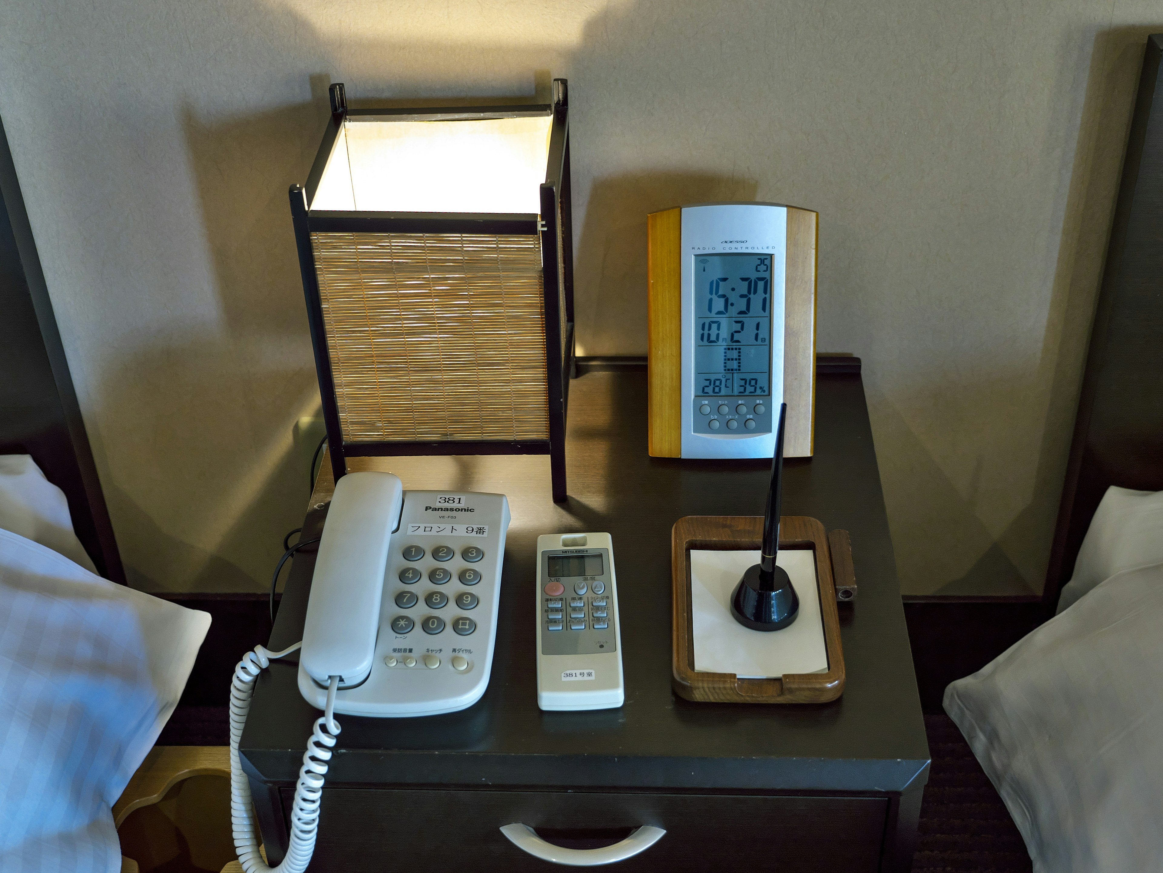 A bedside table featuring a lamp and various telephones