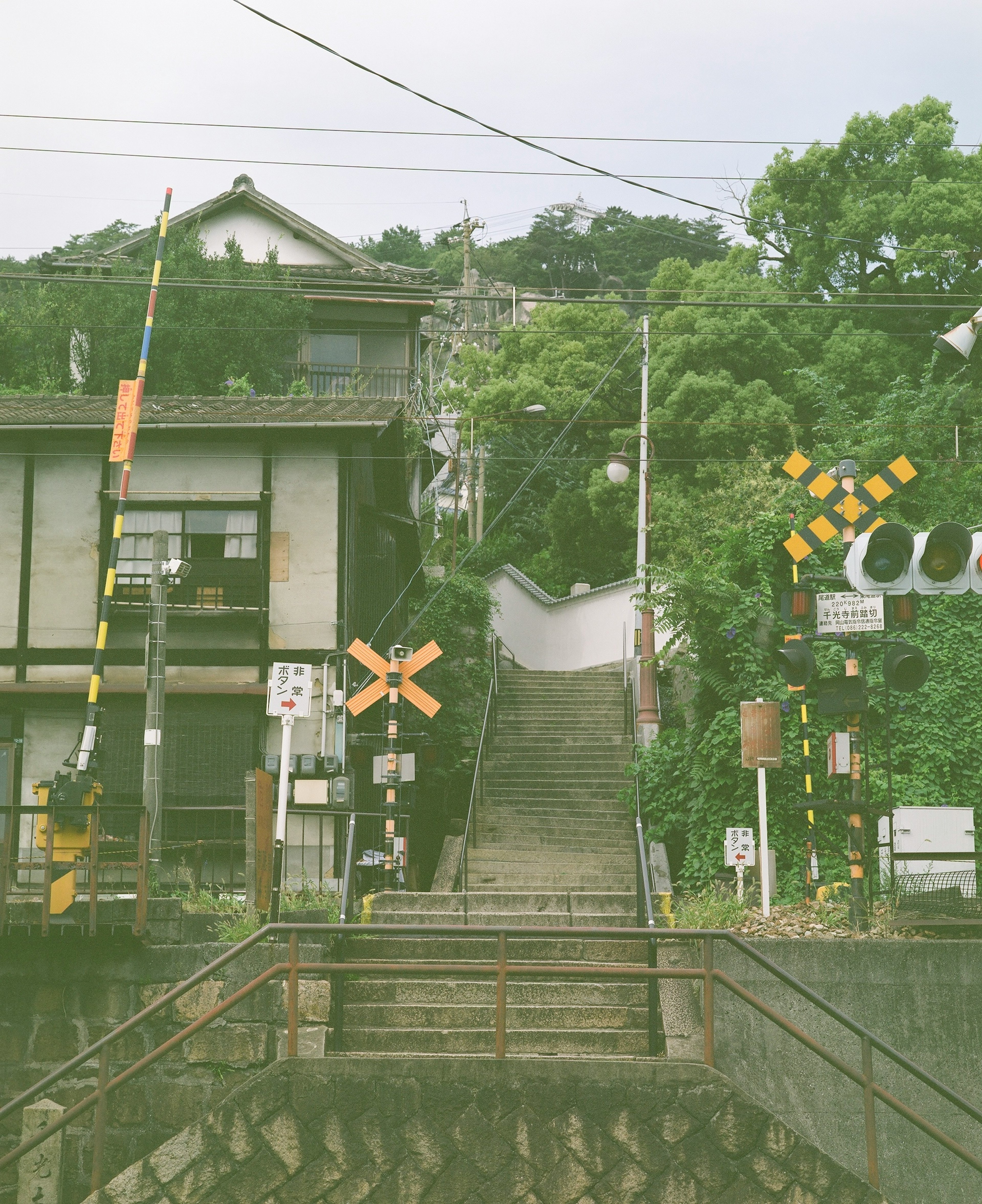 鉄道の踏切の近くにある階段と古い建物