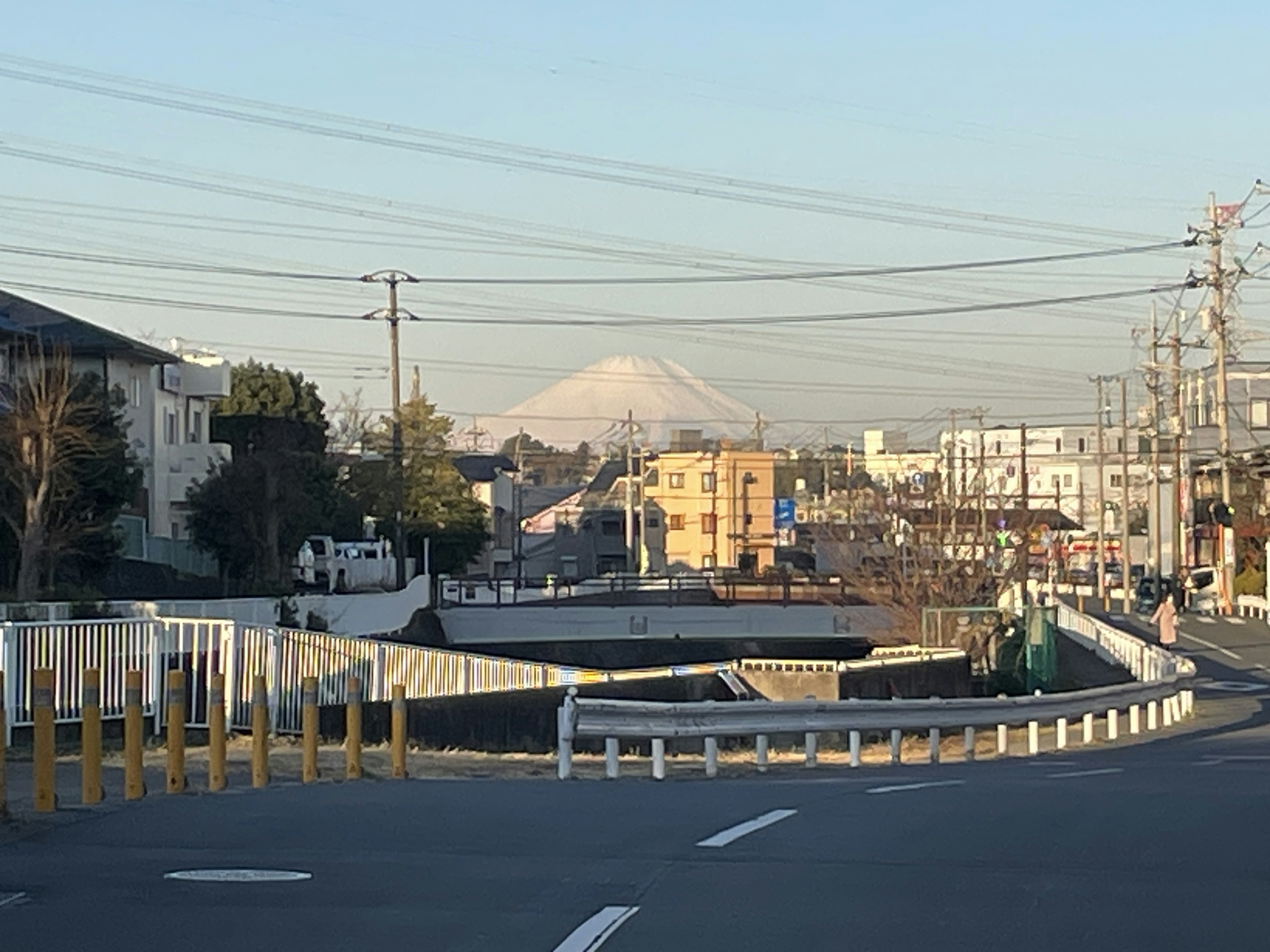 Vue de rue avec le mont Fuji en arrière-plan et des poteaux électriques