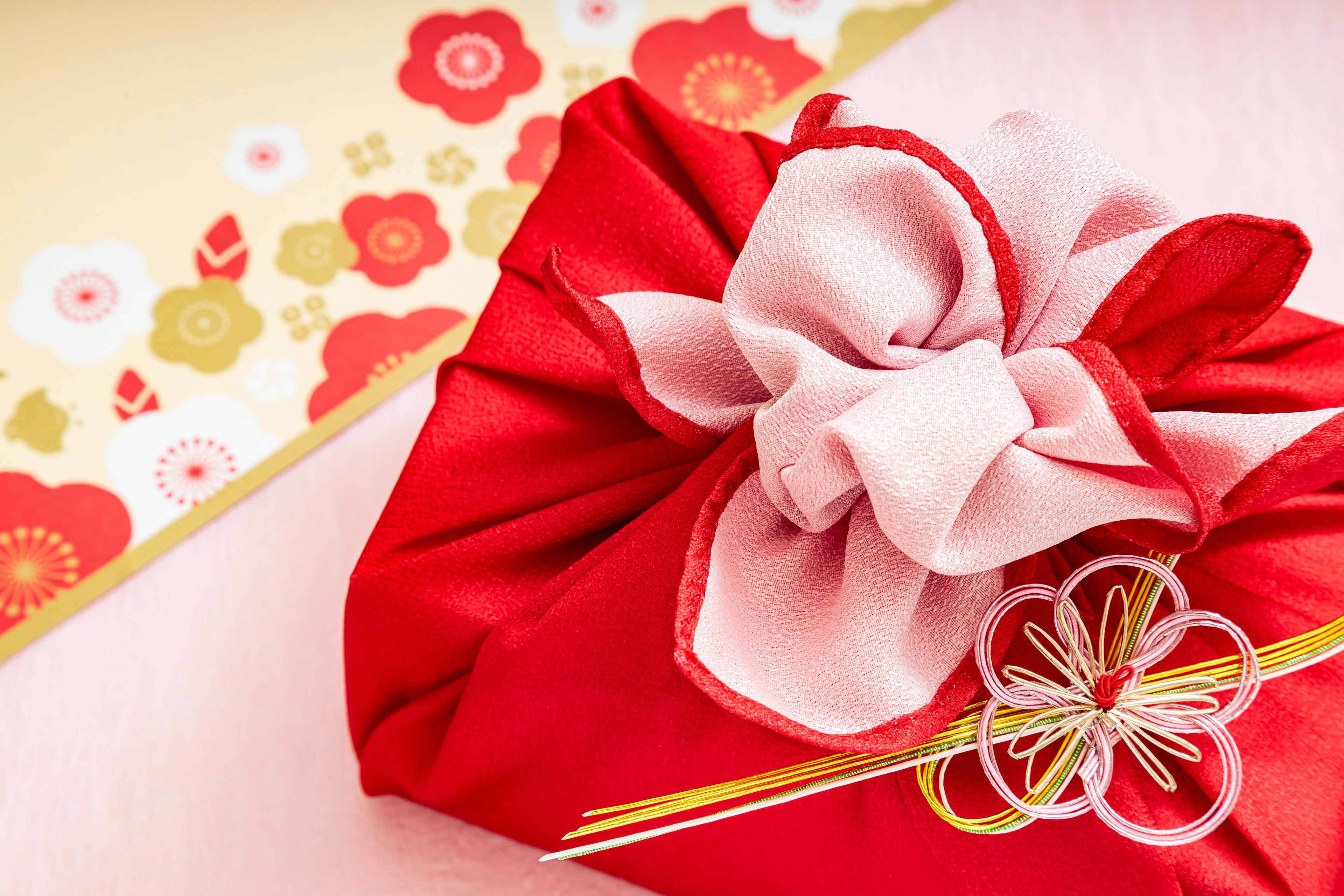 Japanese gift wrapping with red fabric and pink ribbon