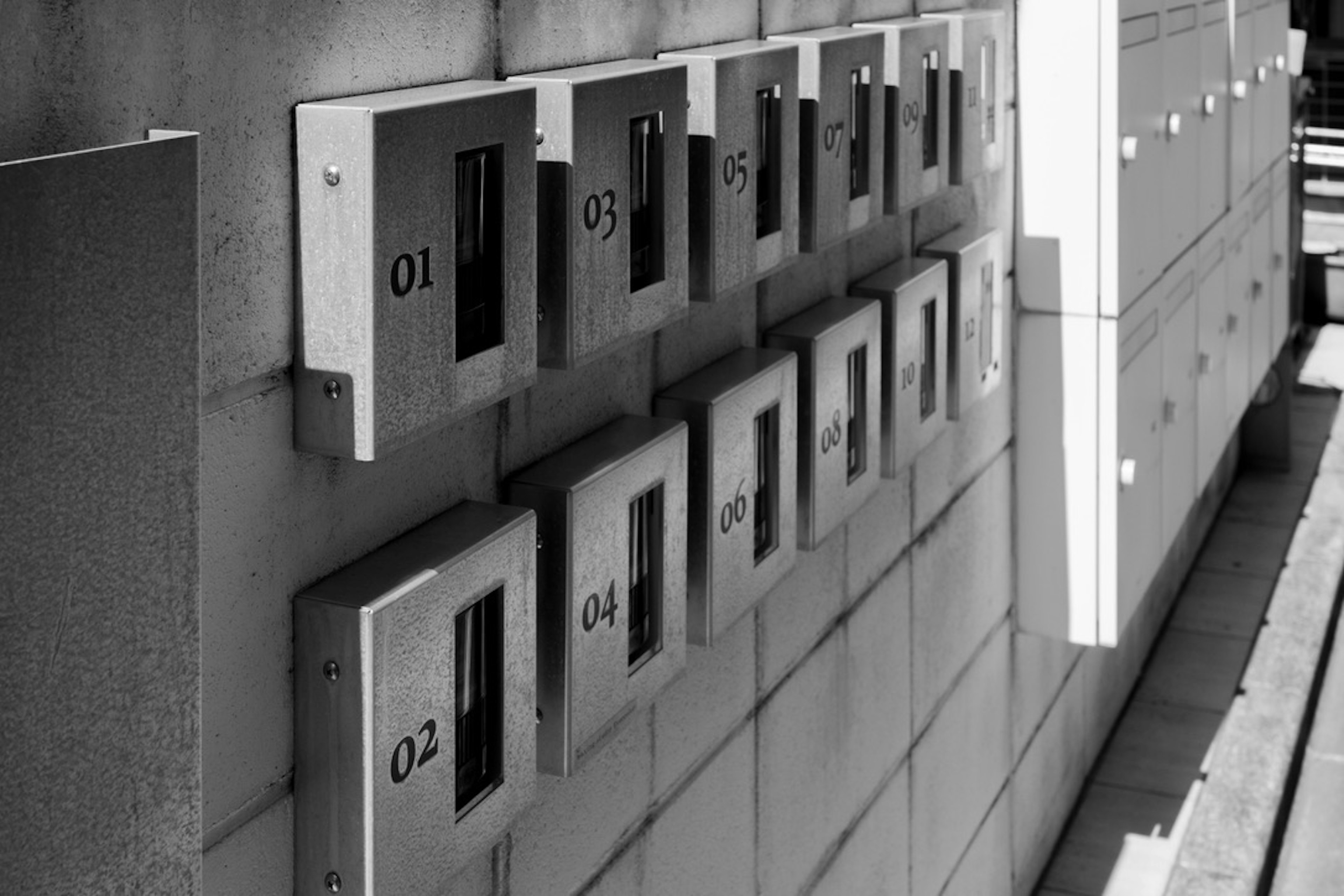 Image of a wall with black and white mailboxes arranged